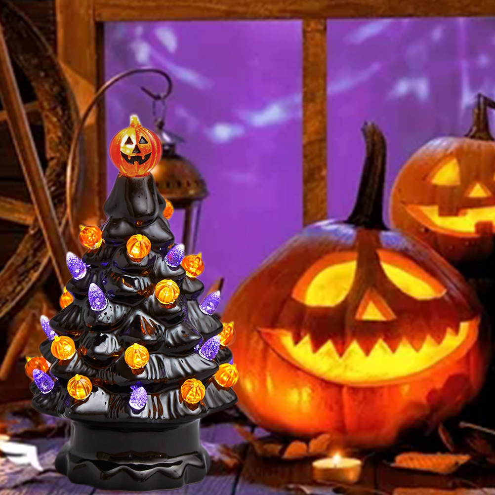 Ein schwarzer Halloween-Baum mit Kürbislichtern und einem Kürbisaufsatz steht in der Nähe von geschnitzten Kürbissen und einem Fenster.