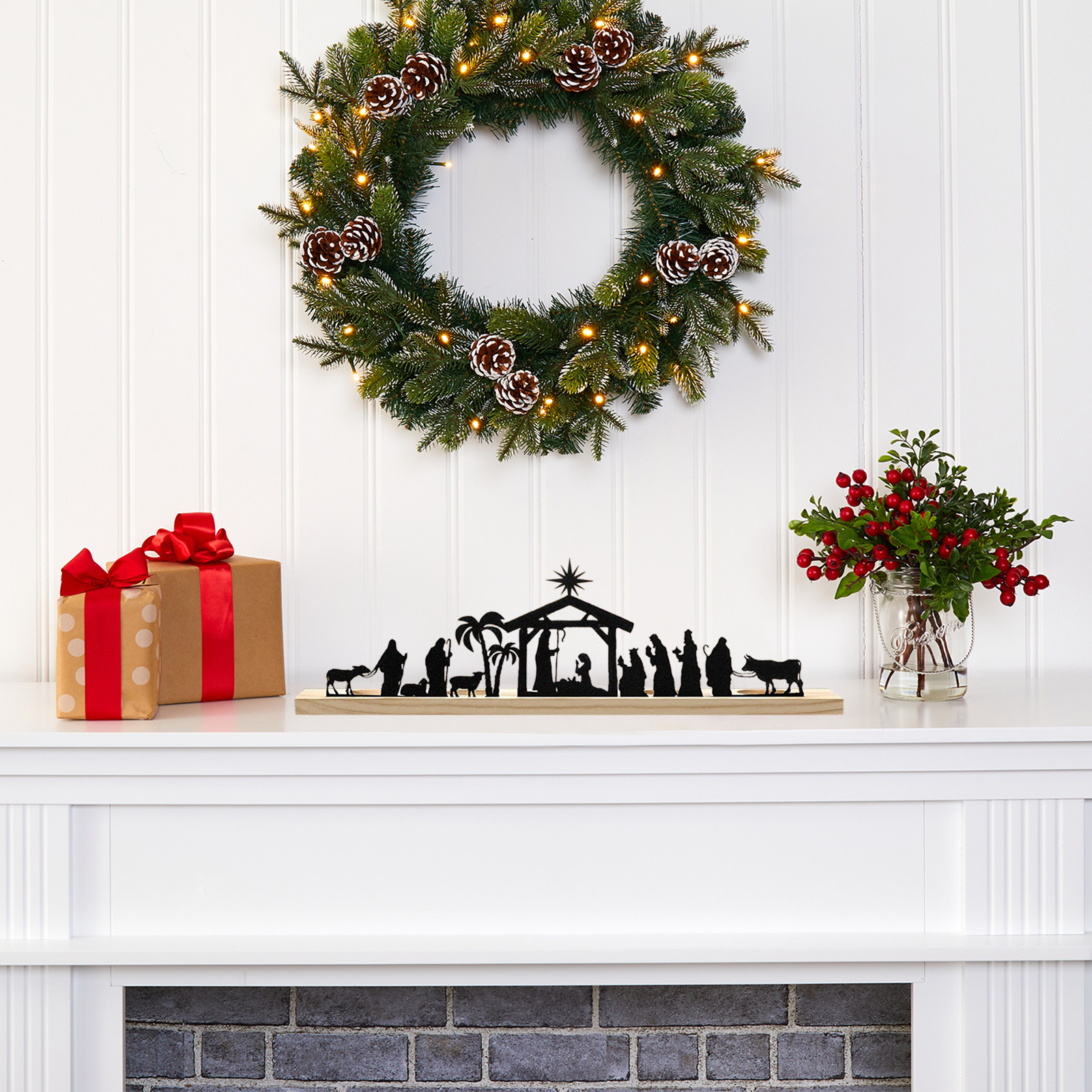 Eine Weihnachtsszene mit Kranz, Geschenken, Krippe und Beeren. Der Kamin ist im Hintergrund sichtbar.