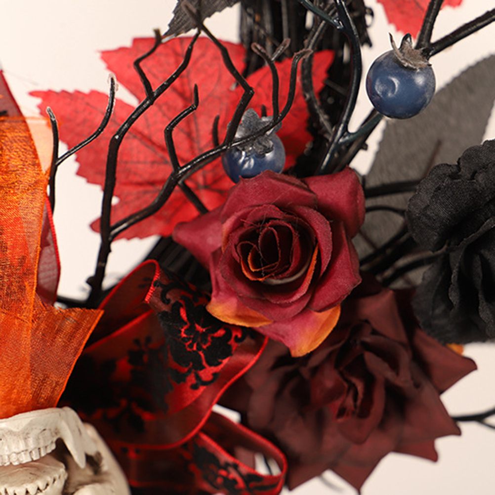Nahaufnahme einer Halloween-Dekoration mit roten Rosen, schwarzen Ästen, roten Blättern, blauen Beeren und einem Totenkopf.