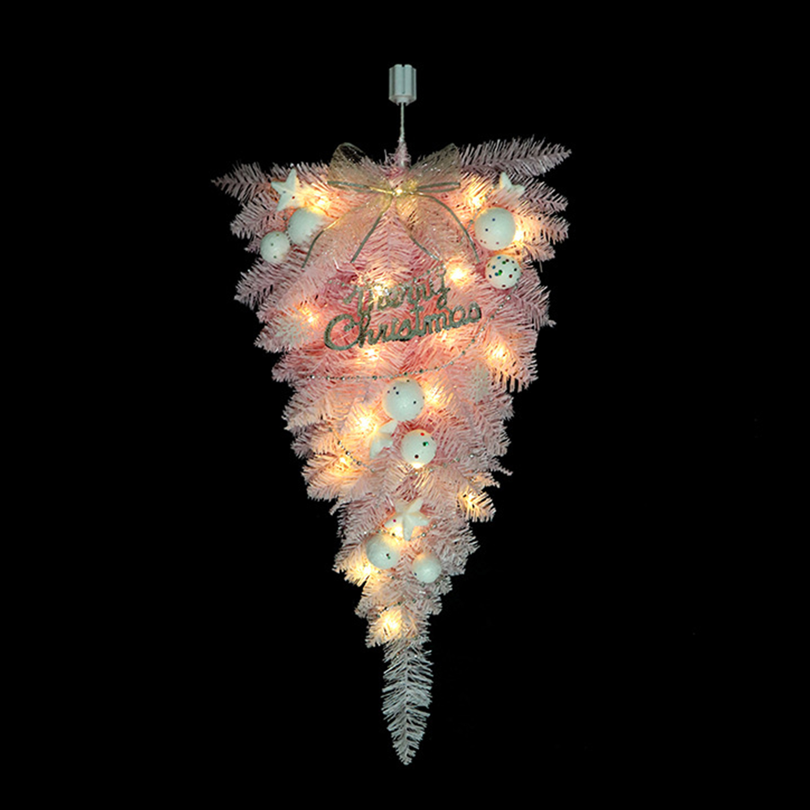 Eine rosa Weihnachtsdekoration mit Lichtern, weißen Kugeln, Sternen und einem "Merry Christmas"-Schild, vor schwarzem Hintergrund.
