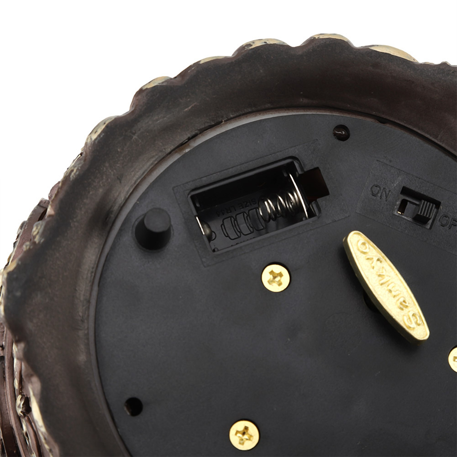 Nahaufnahme der Basis einer Spieluhr mit Batteriefach, Ein/Aus-Schalter, Schrauben und Sankyo-Hebel. Braun, Schwarz und Gold.