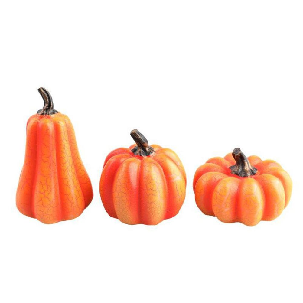 Drei orange Kürbisse mit braunen Stielen auf weißem Hintergrund. Die Kürbisse haben gerippte Oberflächen und variieren in Größe und Form.