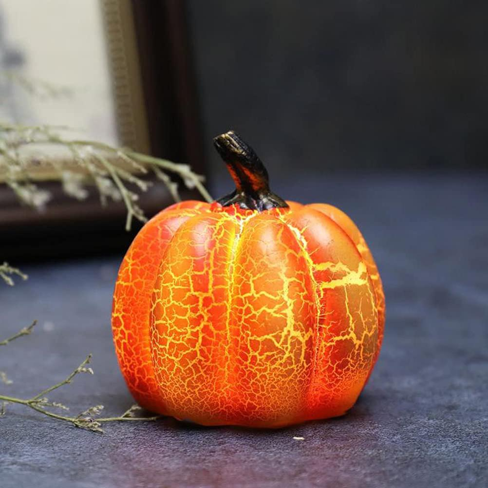 Ein orangefarbener, leuchtender Kürbis mit einem schwarzen Stiel. Rissmuster auf der Oberfläche. Er steht auf dunklem Untergrund.
