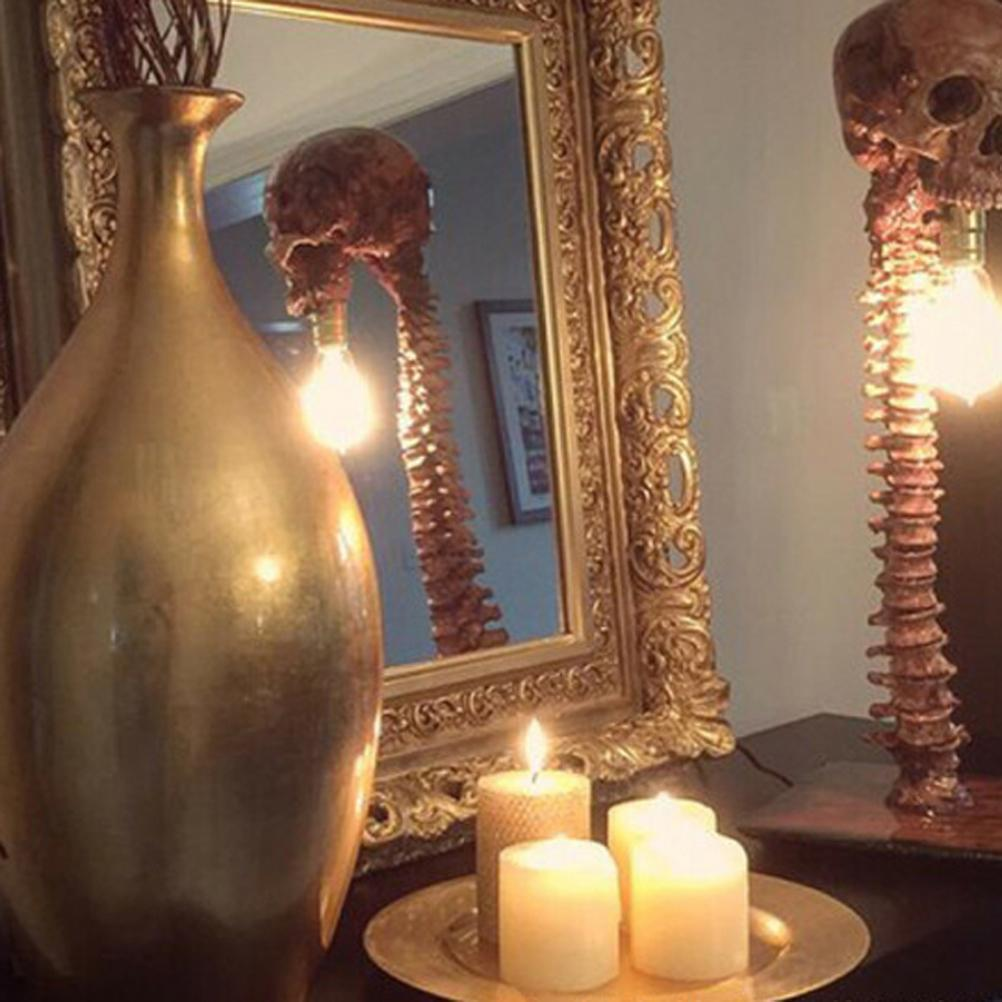 Eine goldene Vase, ein Spiegel, der eine Skelettlampe reflektiert, brennende Kerzen auf einer Goldplatte und eine Skelettlampe. Eine Halloween-Szene.