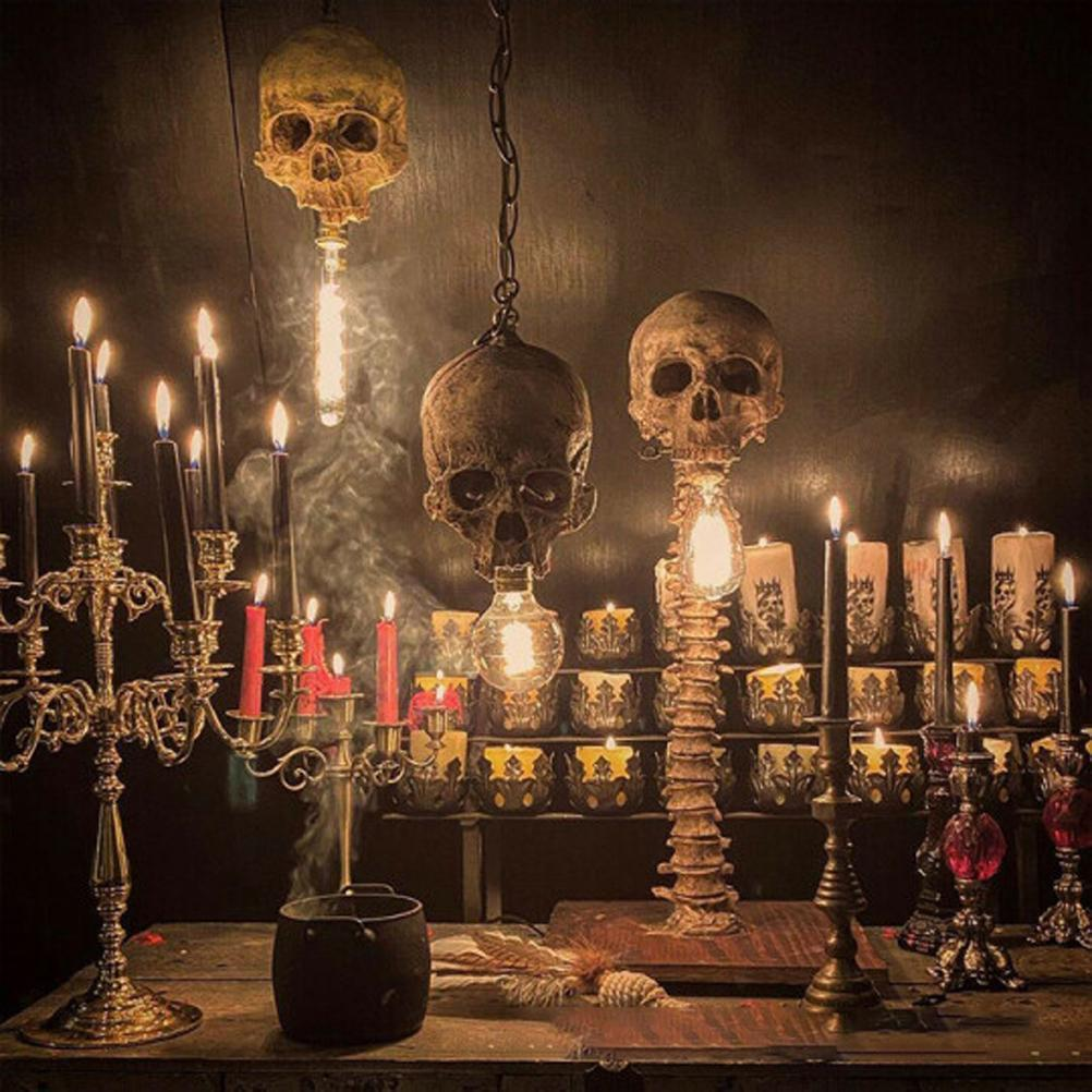 Ein dunkler Raum mit Totenkopf-Leuchten, Kerzen und einem Kessel. Rauch steigt auf. Die Szene hat eine gruselige, Halloween-ähnliche Atmosphäre.