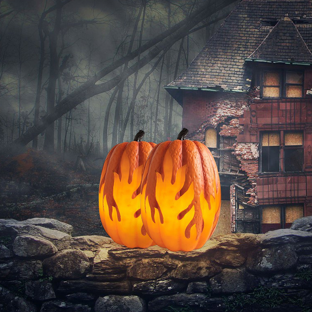 Zwei orangefarbene Kürbisse mit Flammendesigns stehen auf einer Steinmauer. Im Hintergrund ein gruseliges Haus und ein dunkler Wald.