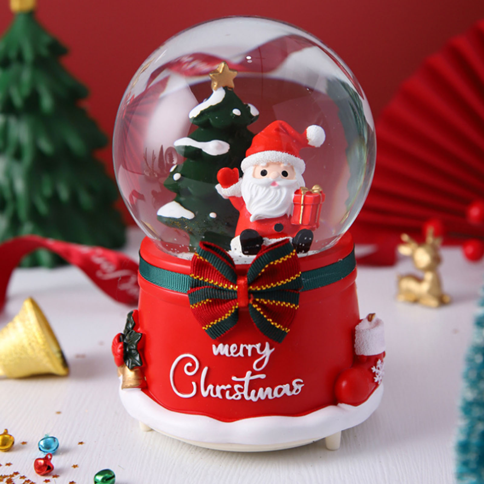 Eine Weihnachtskugel mit Weihnachtsmann, Weihnachtsbaum und den Worten 'Merry Christmas'.