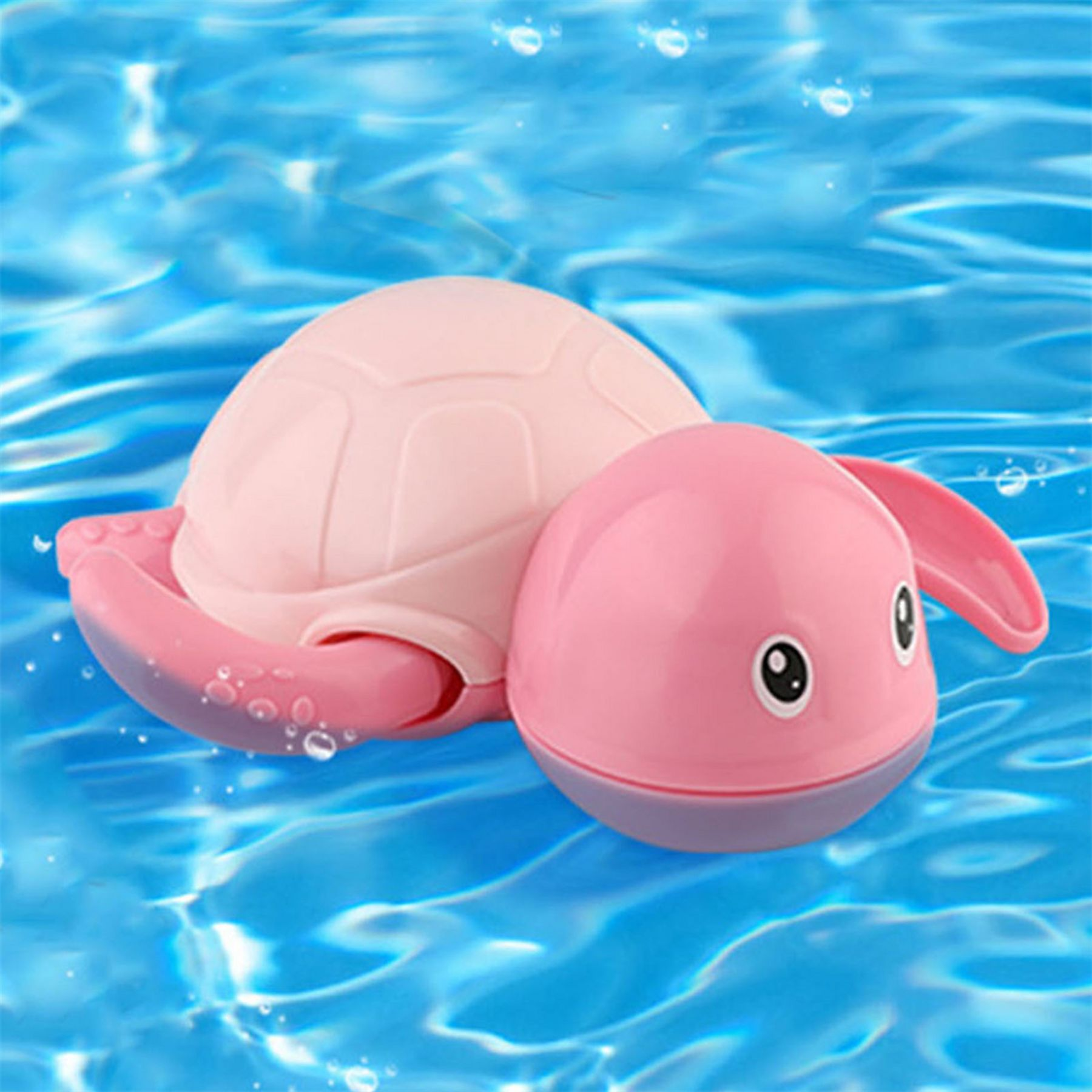 Eine rosa Spielzeugschildkröte schwimmt in blauem Wasser. Die Schildkröte hat einen rosa Panzer, Kopf und Flossen. Blasen umgeben sie.