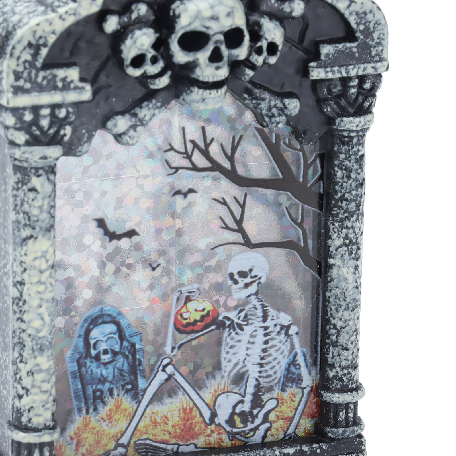 Eine Halloween-Grabstein-Dekoration. Sie hat Totenköpfe, ein Skelett mit einem Kürbis, einen Grabstein und Fledermäuse.