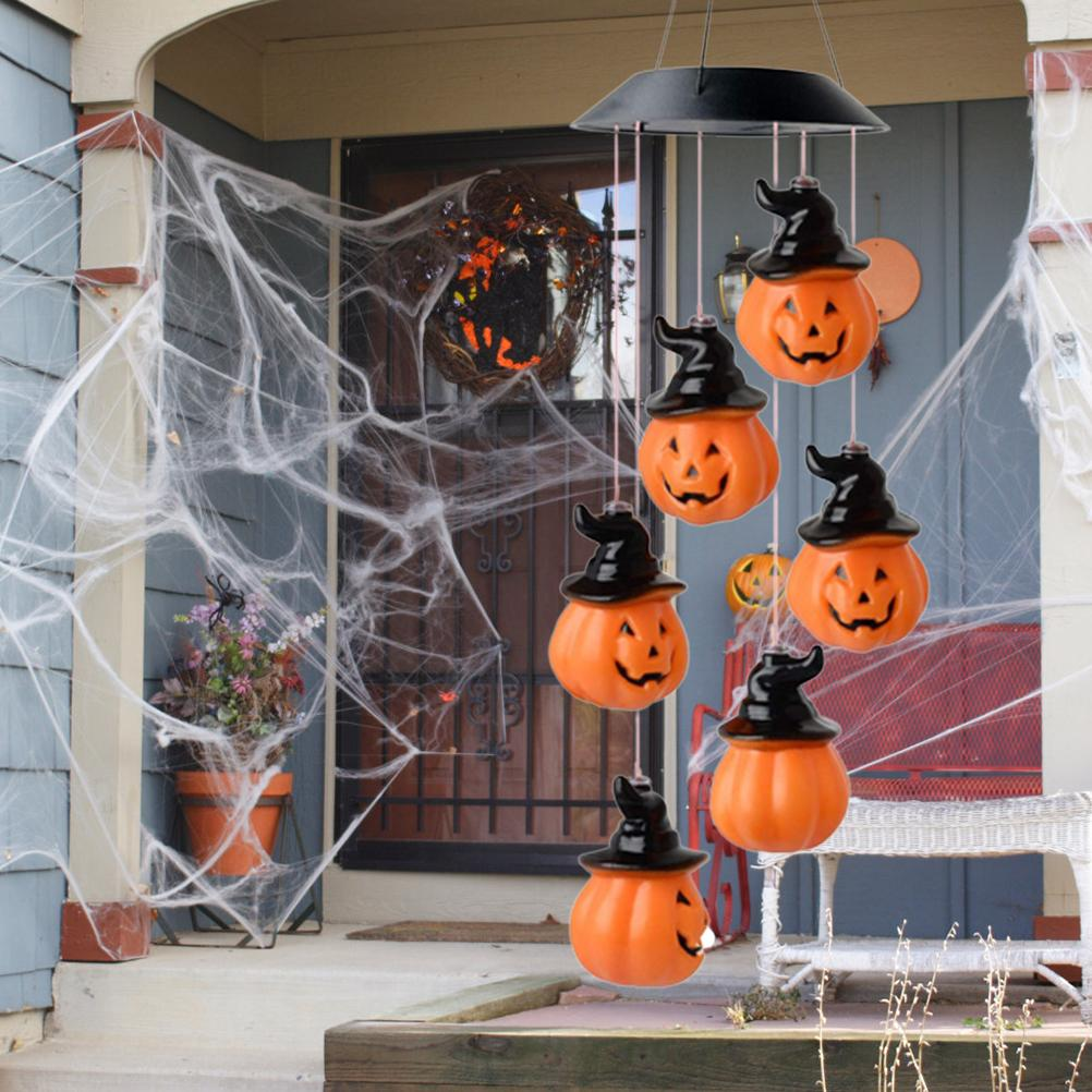 Halloween-Dekoration: Kürbisse mit Hexenhüten, Spinnweben, ein Kranz und ein Blumentopf.