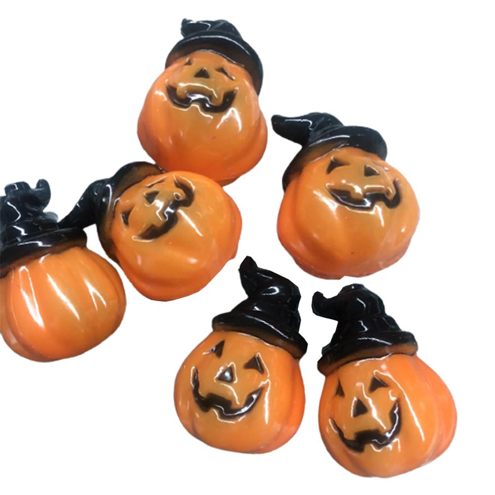 Sechs orangefarbene Kürbisfiguren mit schwarzen Hüten. Jede hat ein geschnitztes, lächelndes Gesicht. Der Hintergrund ist schlicht weiß.