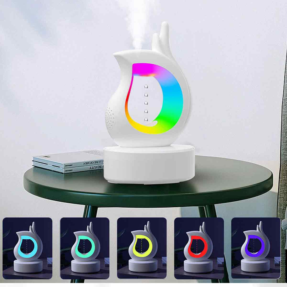 Ein weißer Aromadiffusor mit Regenbogen-Lichtanzeige, der Dampf abgibt. Er steht auf einem runden grünen Tisch mit einem Buch. Mehrere Farboptionen werden gezeigt.