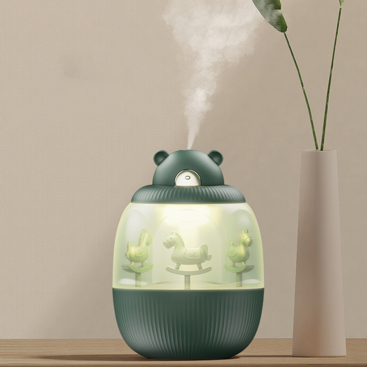 Ein grüner, bärenförmiger Luftbefeuchter mit Spielzeugpferden im Inneren. Dampf tritt oben aus. Rechts eine Vase mit einer Pflanze.