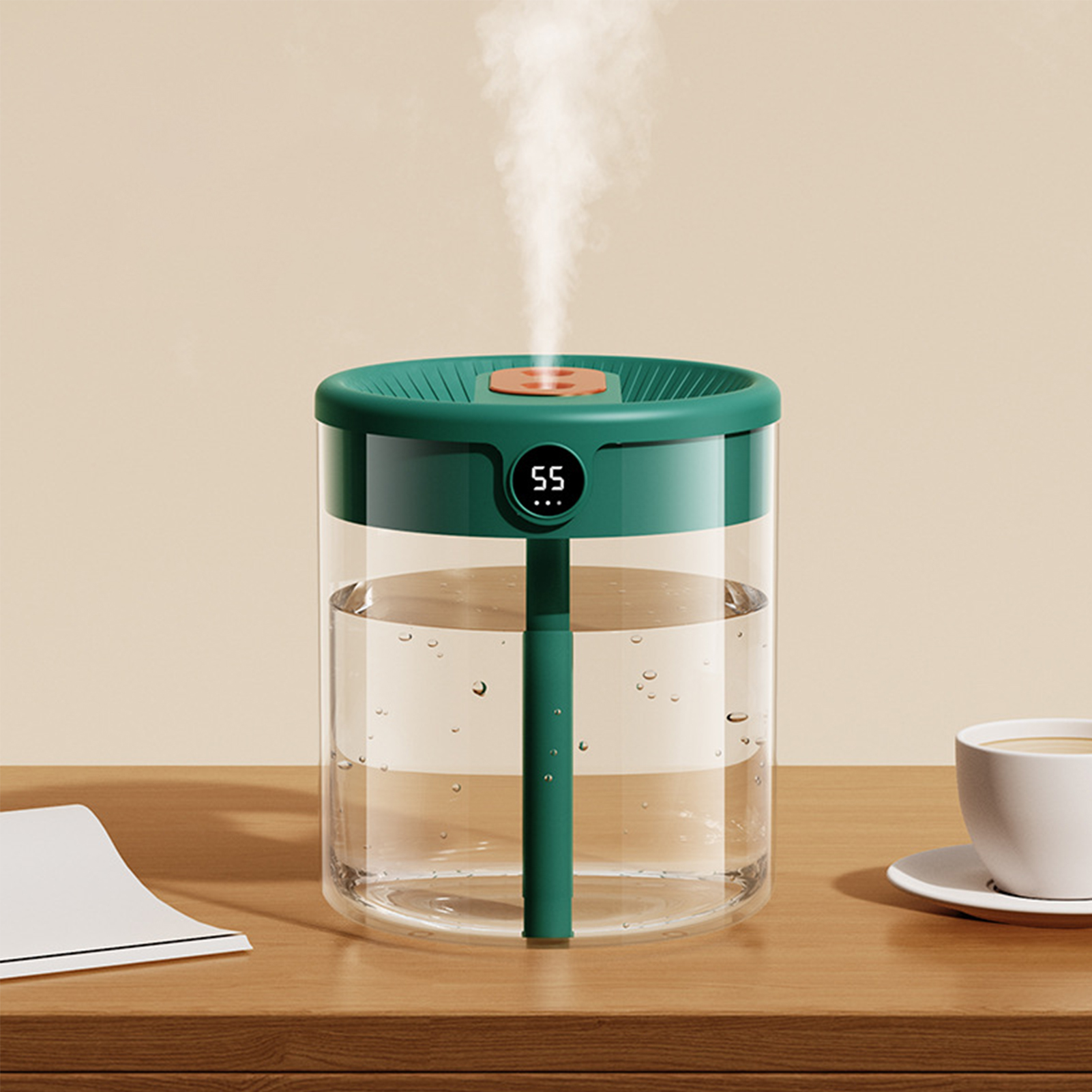 Ein Luftbefeuchter mit grünem Deckel und klarem Wassertank steht auf einem Holztisch. Dampf steigt auf. Eine Tasse Kaffee und Papier liegen daneben.