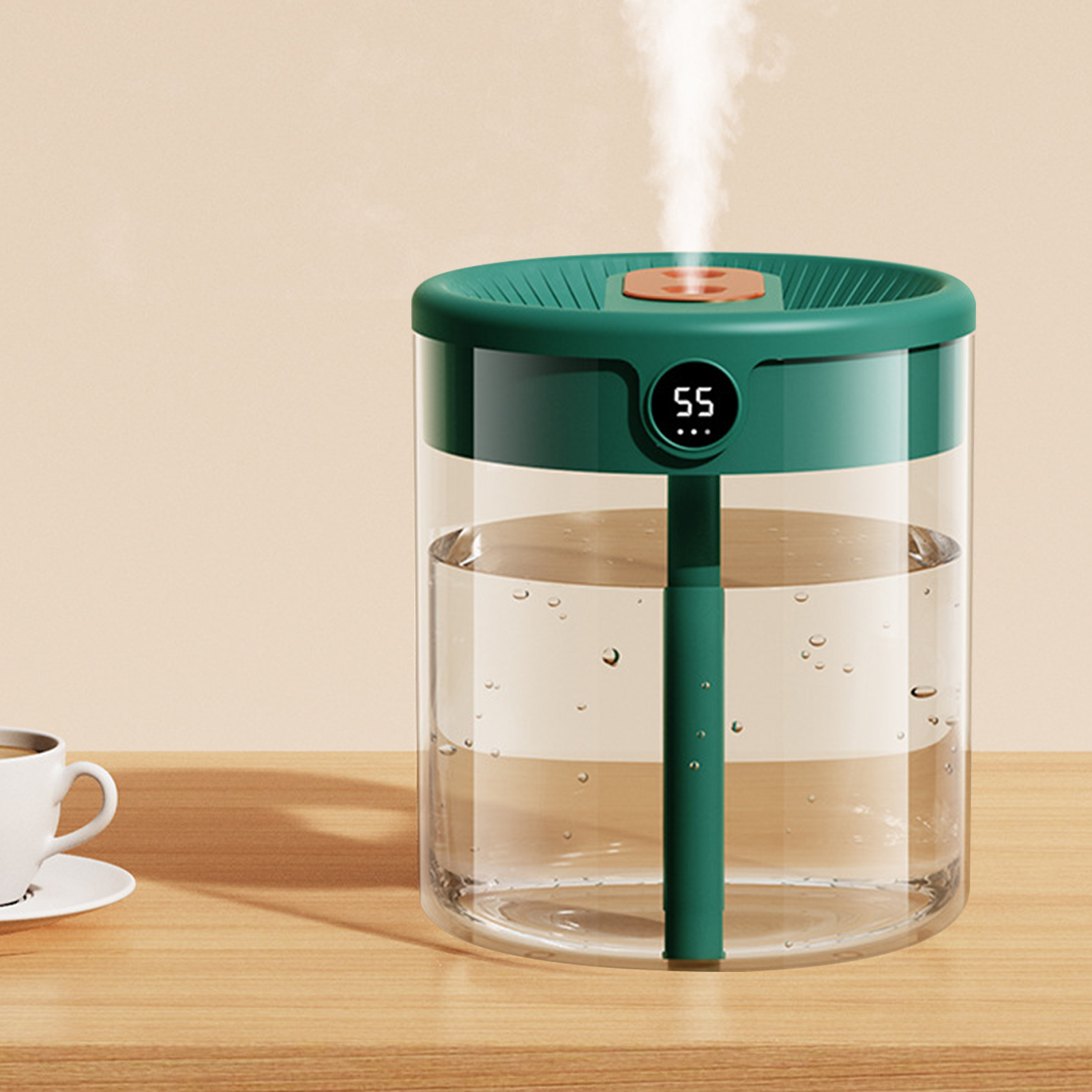 Ein grüner und klarer Luftbefeuchter mit Dampfausstoß. Eine weiße Tasse auf einem Holztisch im Vordergrund.