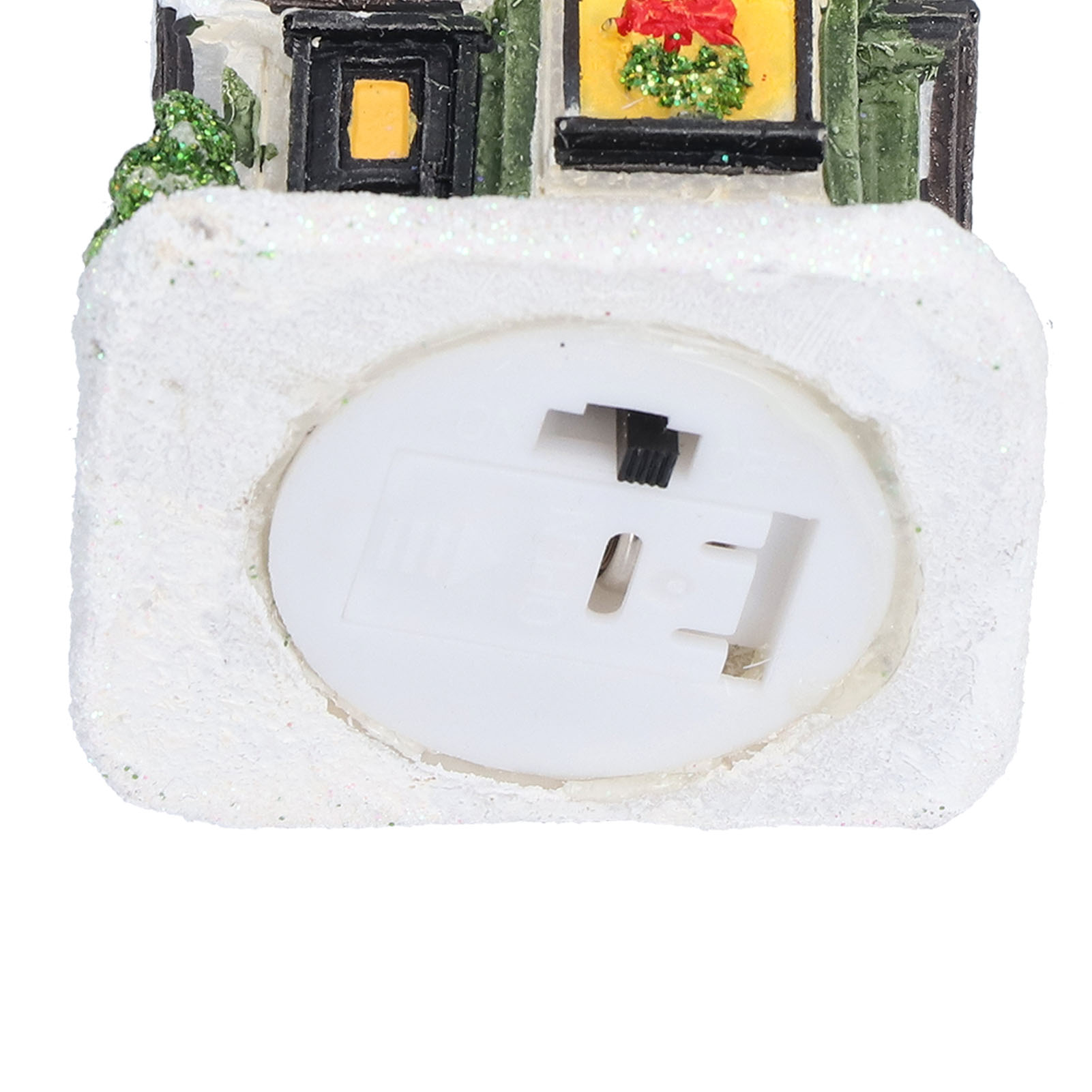 Nahaufnahme eines Miniaturhauses mit Schnee. Mit Fenstern, einer roten Schleife und einem Schalter.