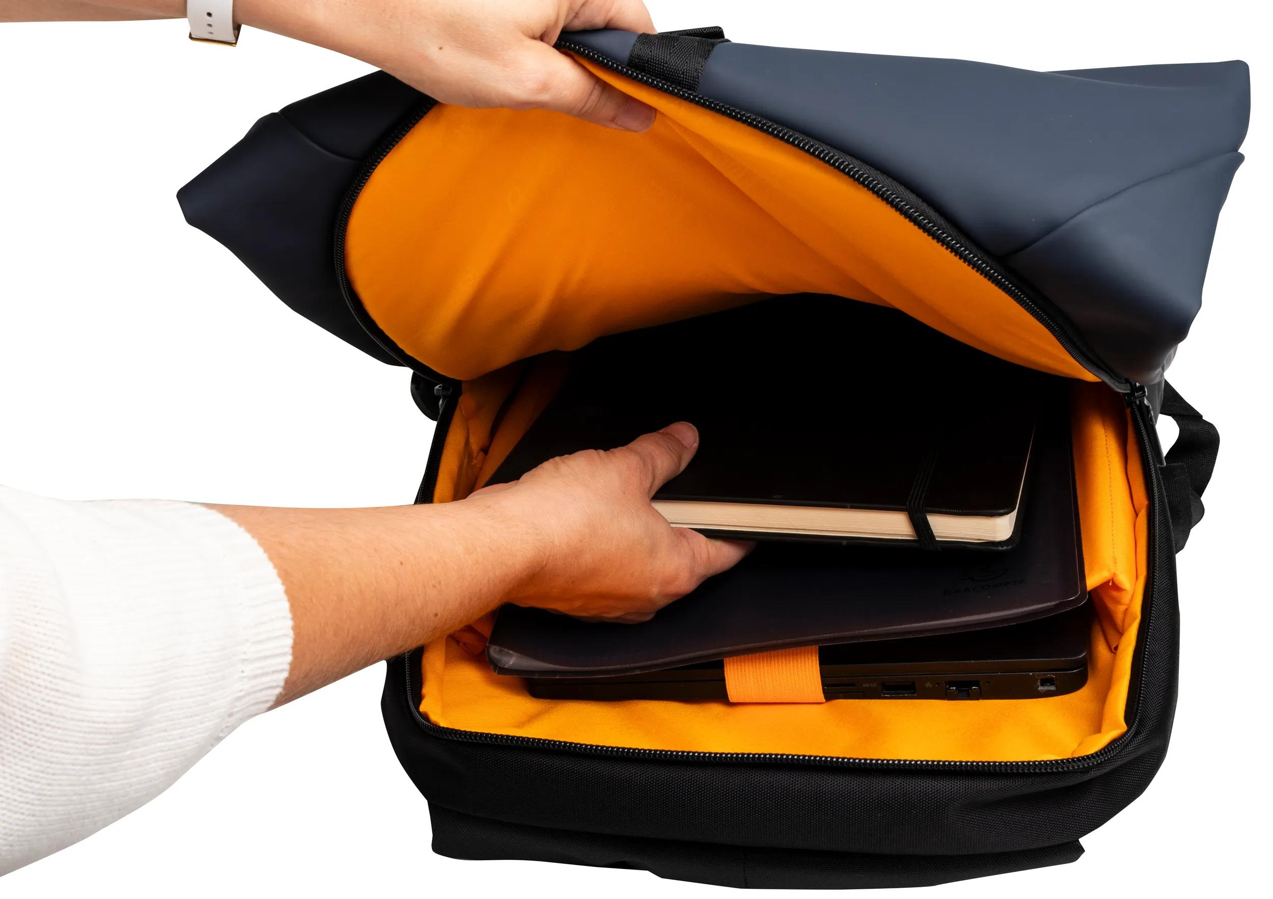 Eine Person öffnet einen schwarzen Rucksack mit orangefarbenem Innenraum, der einen Laptop und ein Notizbuch zeigt.