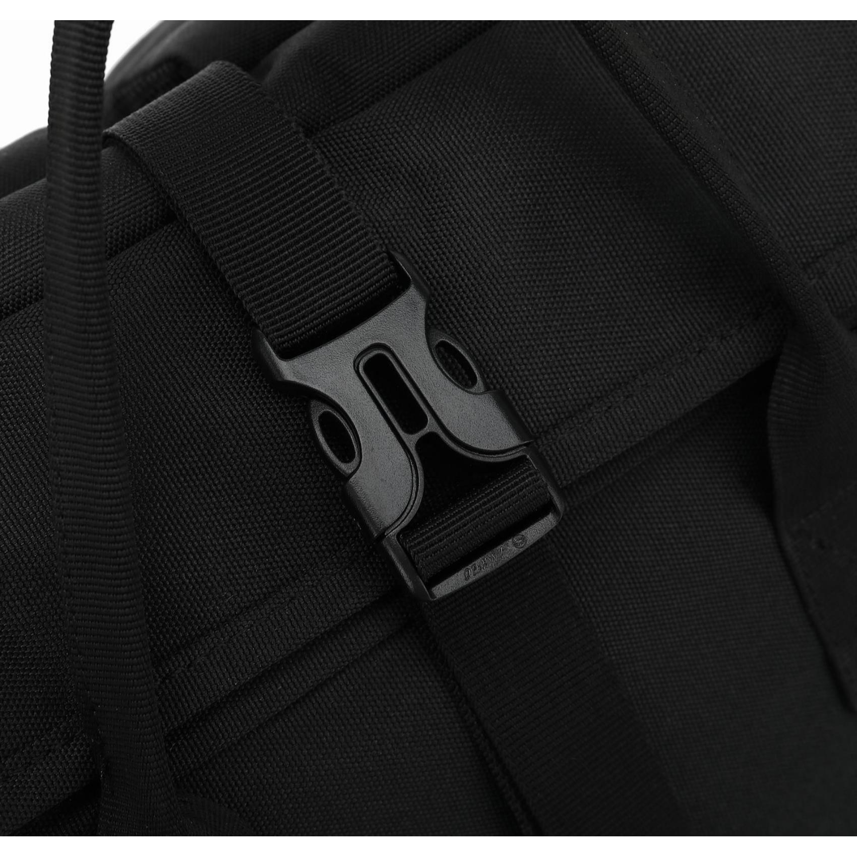 Nahaufnahme einer schwarzen Rucksackschließe. Die Schnalle ist aus Kunststoff und mit schwarzen Riemen verbunden. Der Hintergrund ist schwarz.