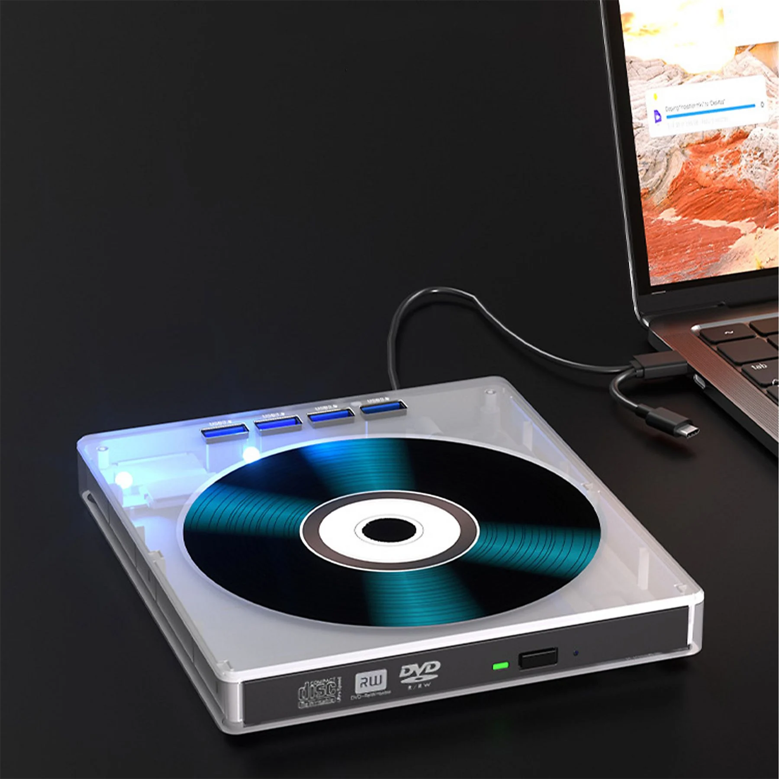 Ein DVD-Laufwerk ist an einen Laptop angeschlossen. Das Laufwerk hat eine Disc im Inneren und befindet sich auf einer dunklen Oberfläche.