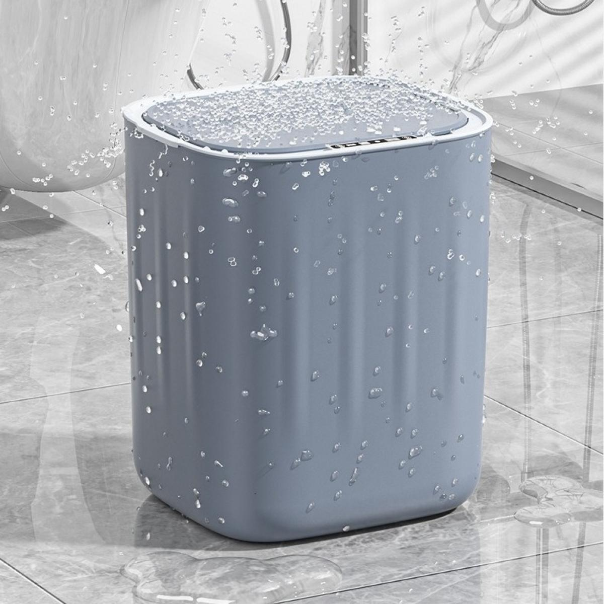 Ein blauer Mülleimer mit Deckel in einem Badezimmer. Wassertropfen bedecken den Eimer, der auf Fliesen steht.