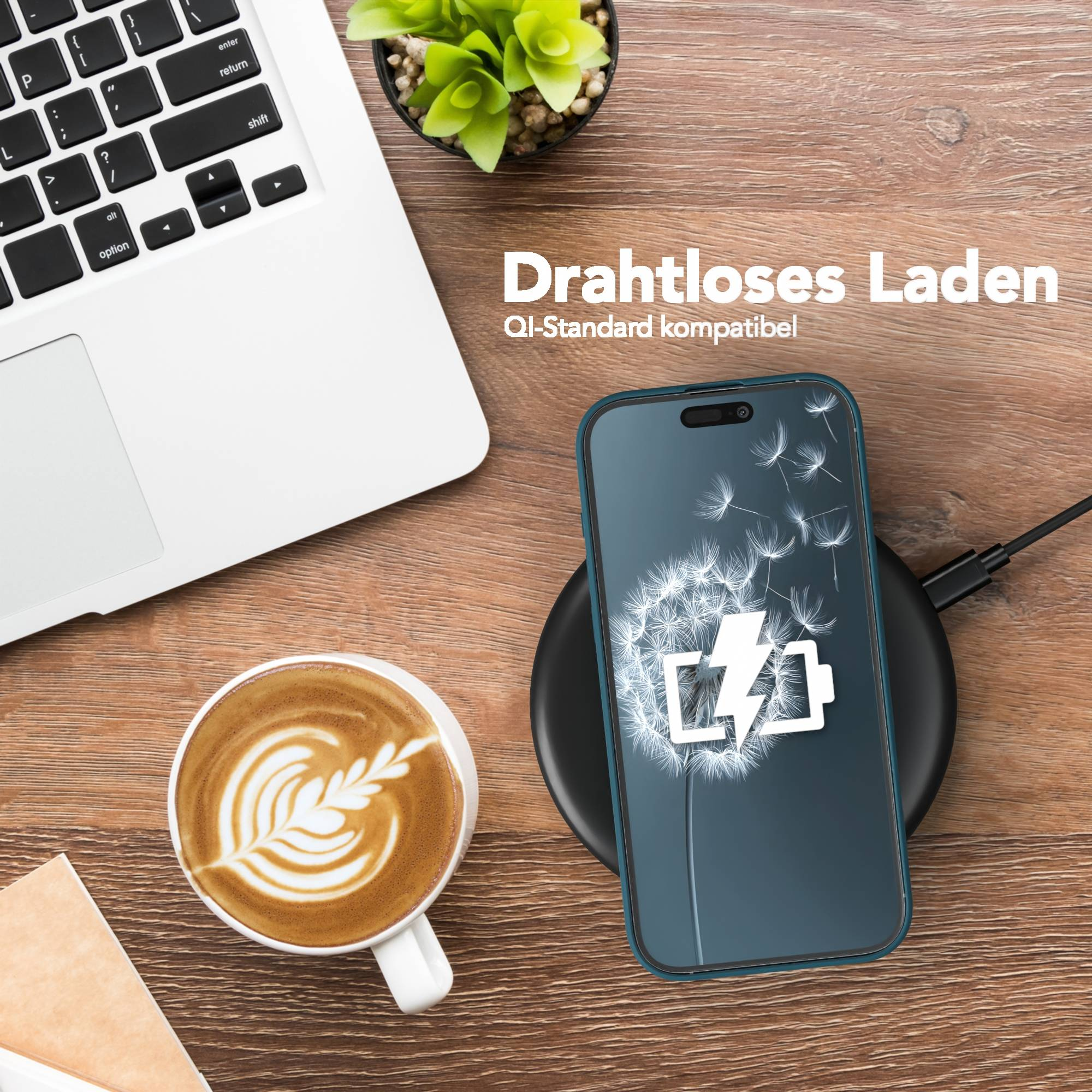 Telefon, das drahtlos auf einem Pad geladen wird, neben einem Laptop, Kaffee und Pflanze auf einem Holztisch.