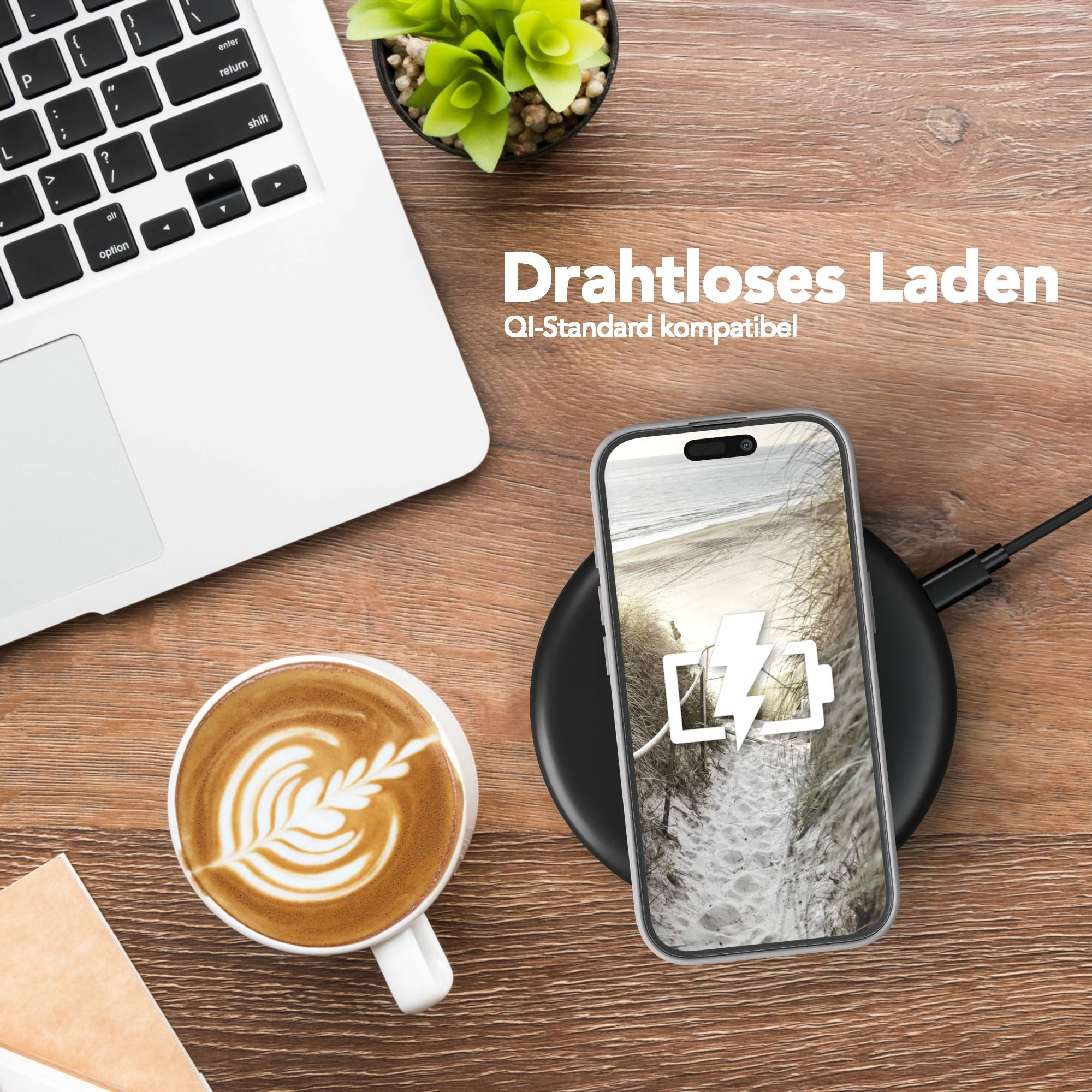Ein Telefon wird drahtlos aufgeladen, angezeigt auf einem Ladegerät. Ein Laptop und eine Kaffeetasse sind ebenfalls auf der Holzoberfläche.