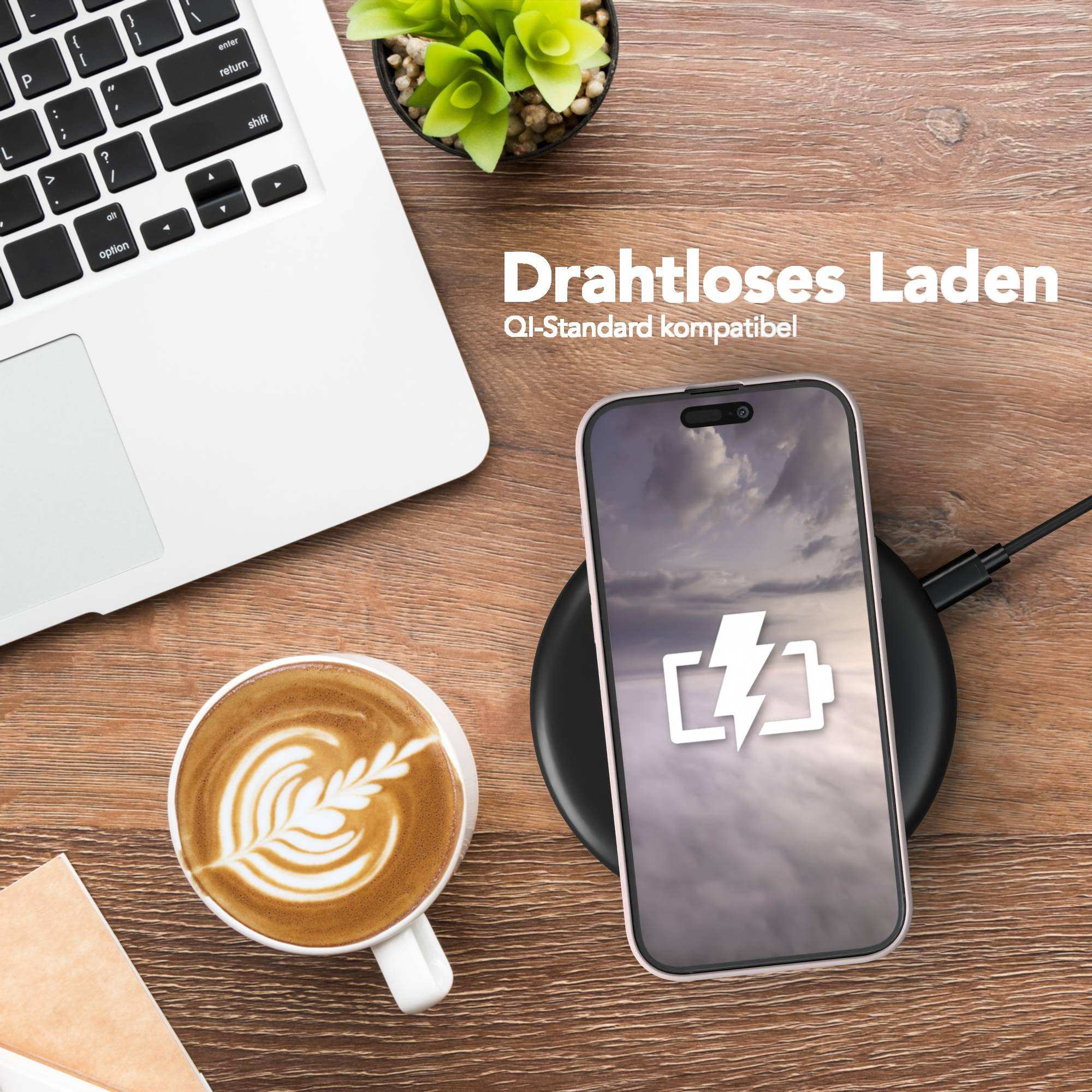 Ein Telefon auf einem kabellosen Ladegerät, Kaffee, ein Laptop und eine Pflanze auf einer Holzoberfläche. Das Telefon zeigt ein Ladesymbol.