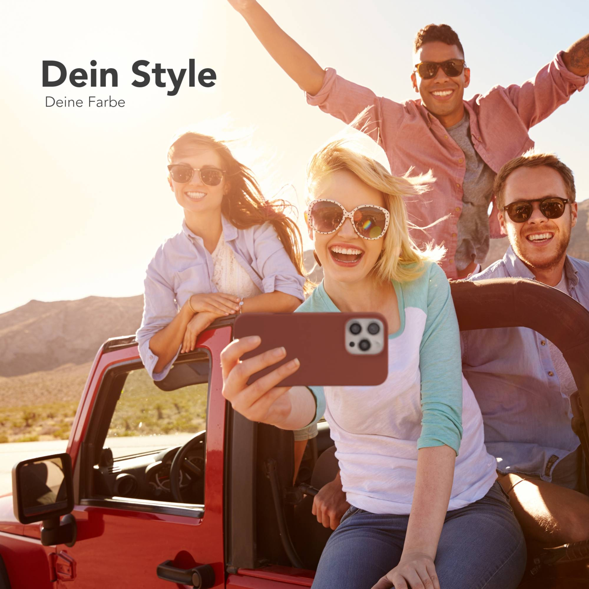 Freundesgruppe in einem roten Auto macht ein Selfie. Sie lächeln und tragen Sonnenbrillen und genießen den sonnigen Tag.