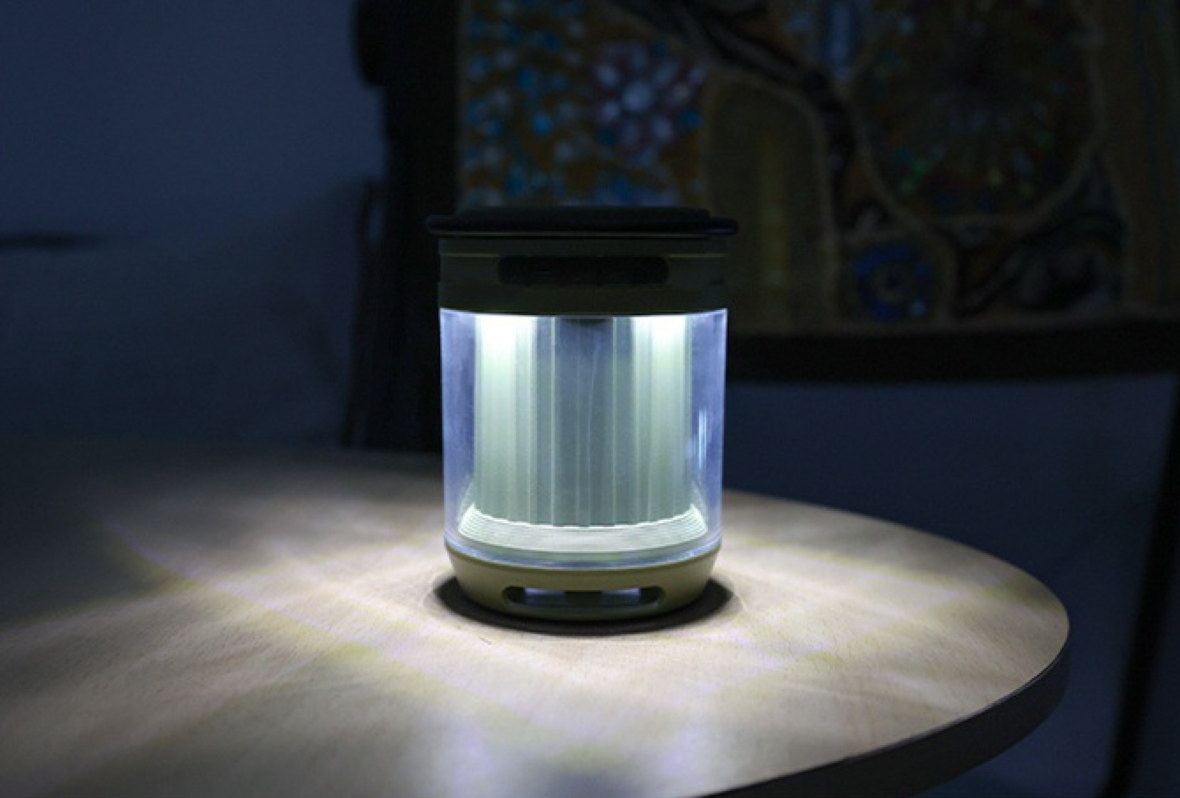 Eine leuchtende Laterne auf einem Tisch in einem dunklen Raum. Das Licht scheint auf den Tisch. Der Hintergrund ist dunkel.