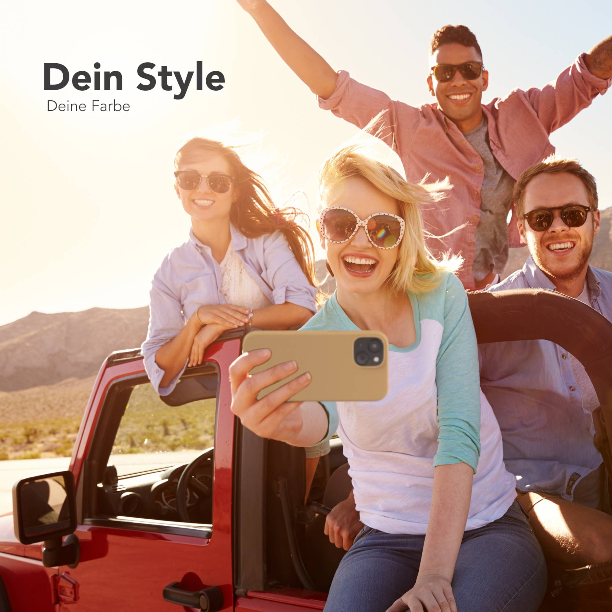 Eine Gruppe von Freunden macht ein Selfie in einem roten Jeep. Einer hebt die Arme, andere lächeln, und Berge sind im Hintergrund.