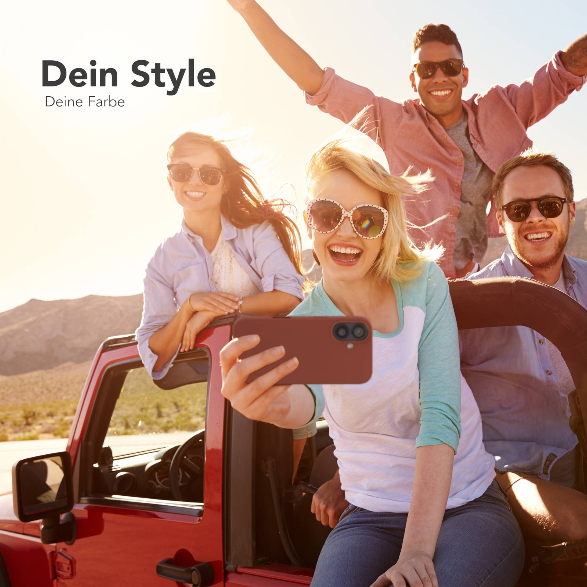 Freundesgruppe macht Selfie in rotem Jeep. Eine Person hat die Arme erhoben.