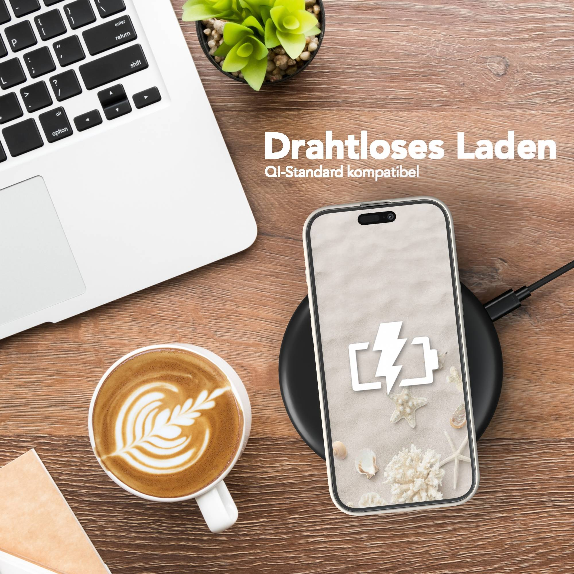 Ein Telefon auf einem kabellosen Ladegerät neben einem Laptop und Kaffee. Das Telefon zeigt ein Batteriesymbol.
