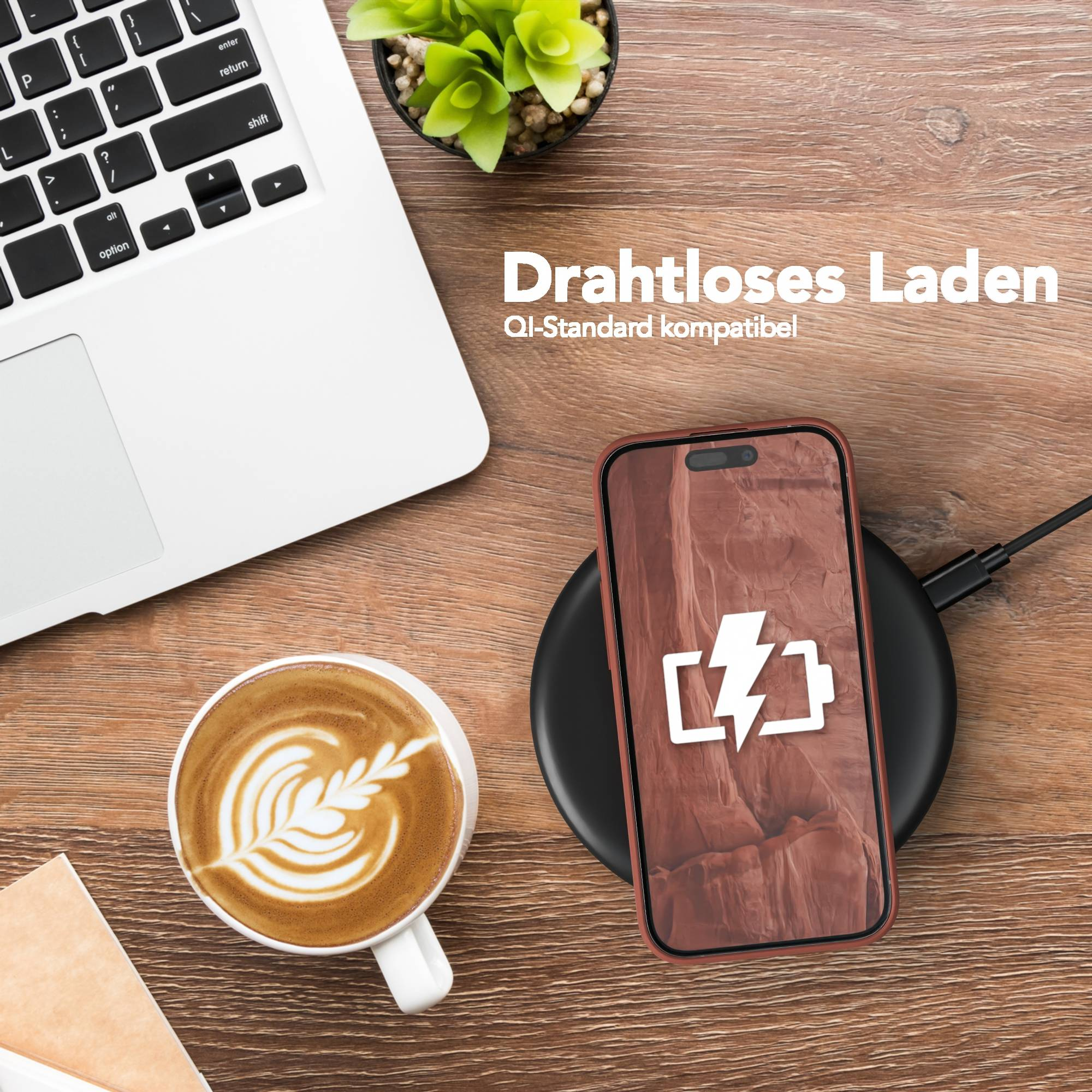 Ein Telefon, das drahtlos auf einem Holztisch geladen wird, neben einem Laptop und Kaffee. Das Telefon zeigt ein Ladesymbol.