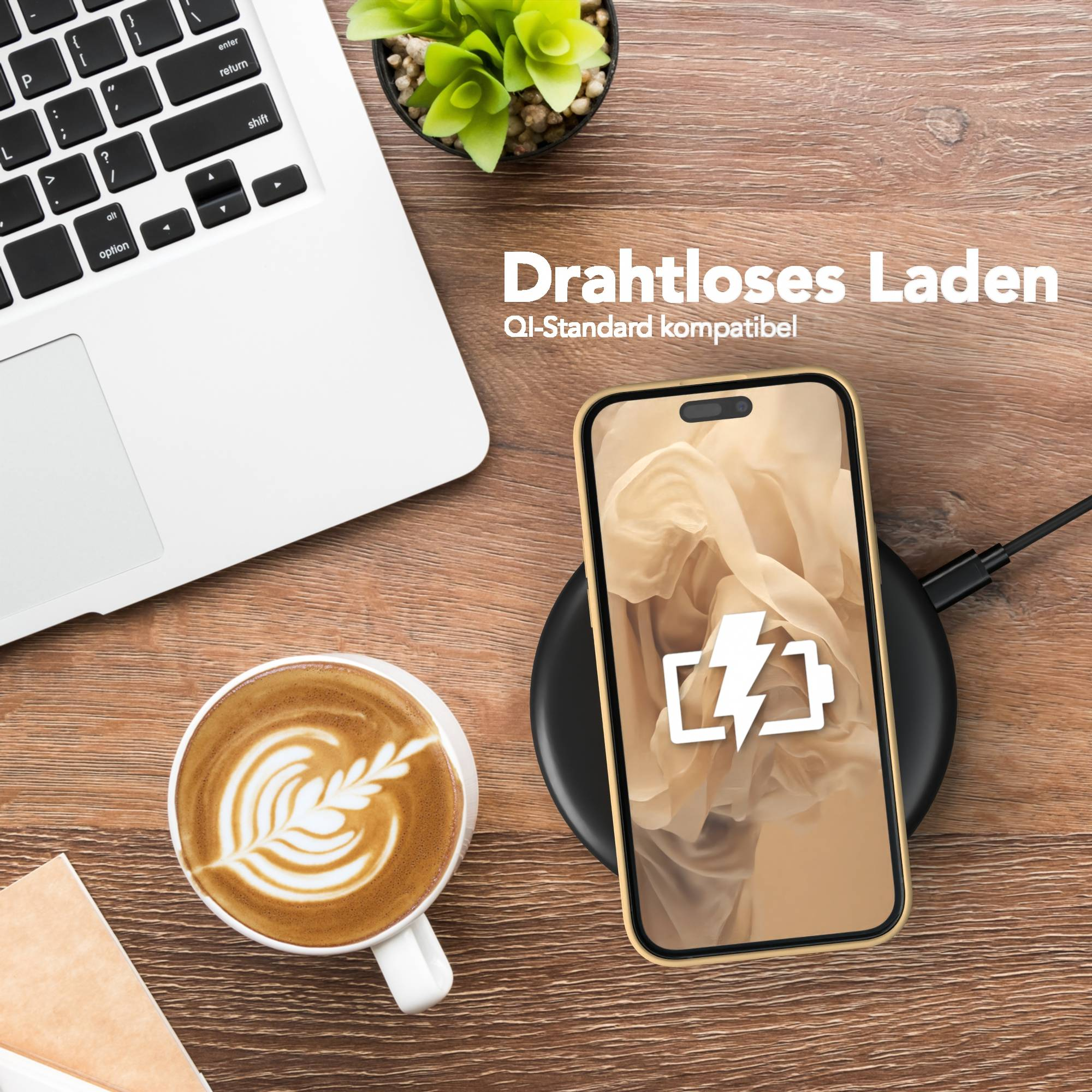 Ein Telefon auf einem kabellosen Ladegerät, Laptop, Kaffee und eine Pflanze auf einem Holztisch. Das Telefon zeigt ein Ladesymbol.