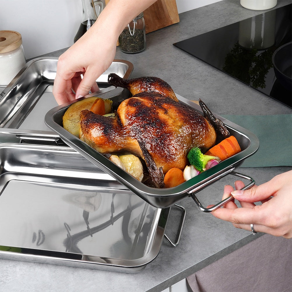 Un pollo asado con verduras está en una bandeja de metal. Unas manos sostienen la bandeja. Otras bandejas están debajo. Ambiente de cocina.