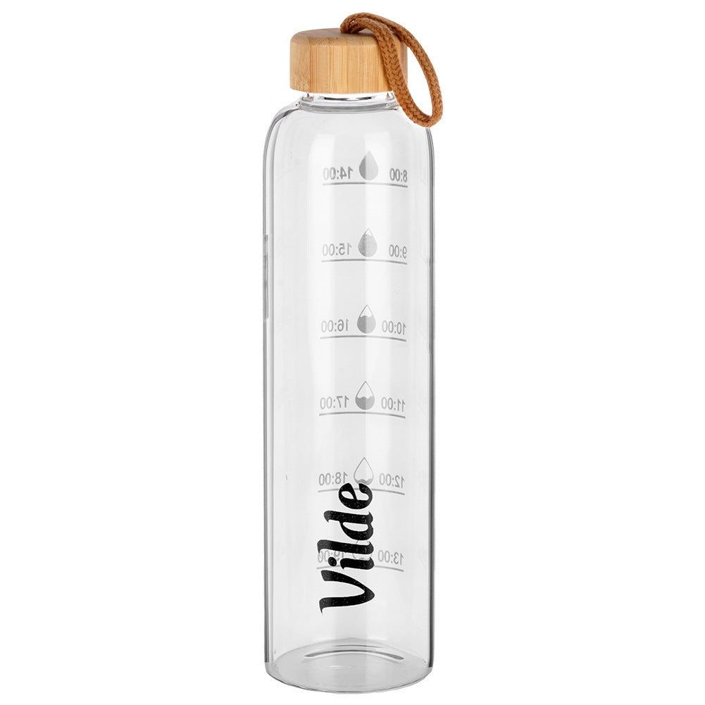 Una botella de agua de vidrio transparente con tapa de madera y lazo marrón. Tiene marcas de tiempo y el nombre 'Vilde'.