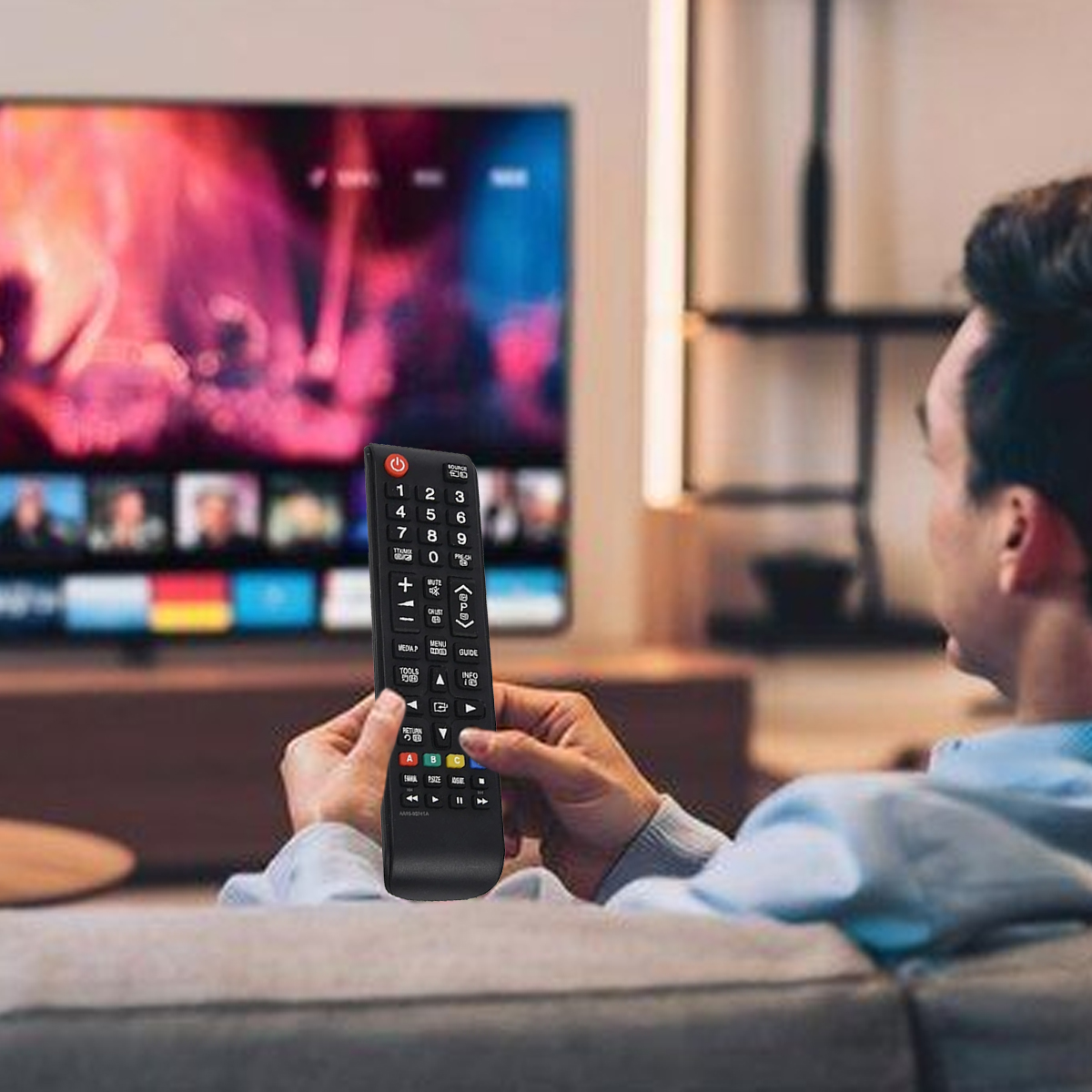 Ein Mann hält eine TV-Fernbedienung und sieht fern. Der Fernseher zeigt Bilder. Der Mann sitzt auf einem Sofa. Der Hintergrund hat Regale.