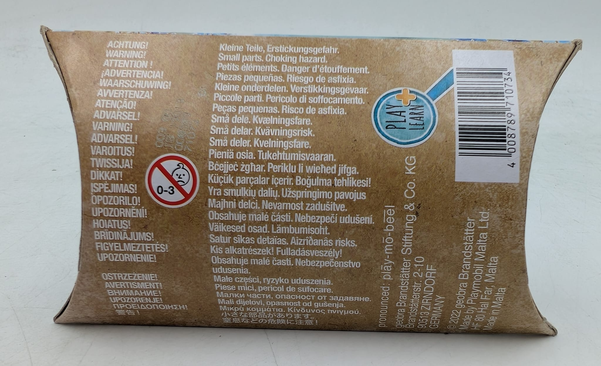 Cardboard box with safety warnings in multiple languages, including choking hazard and small parts. Contains a Play & Learn logo.