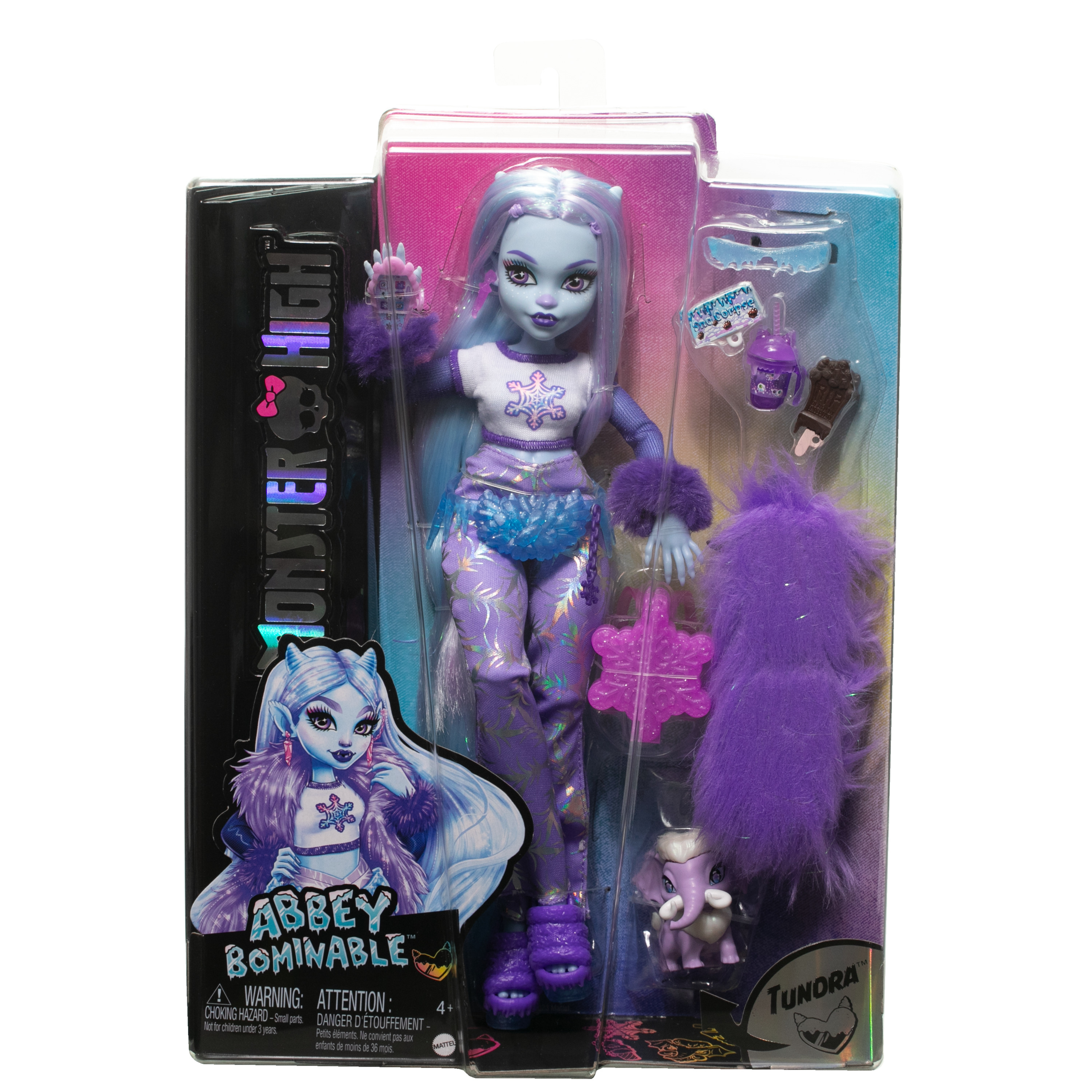Lalka Monster High w pudełku. Ma niebieską skórę, fioletowe włosy i nosi biały top ze śnieżynkami.
