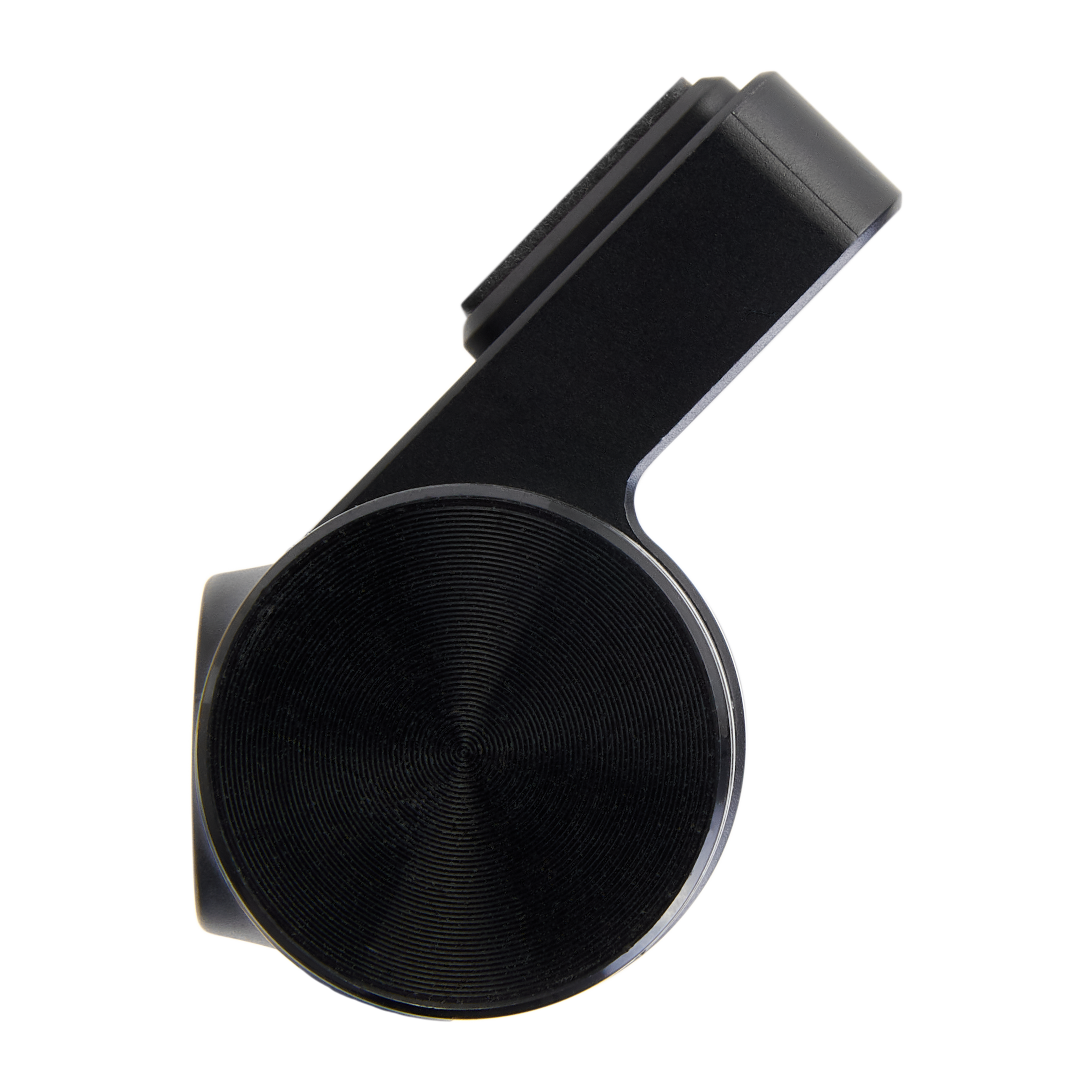 Close-up of a black object with a circular, textured base and an angled top section. Background is black.