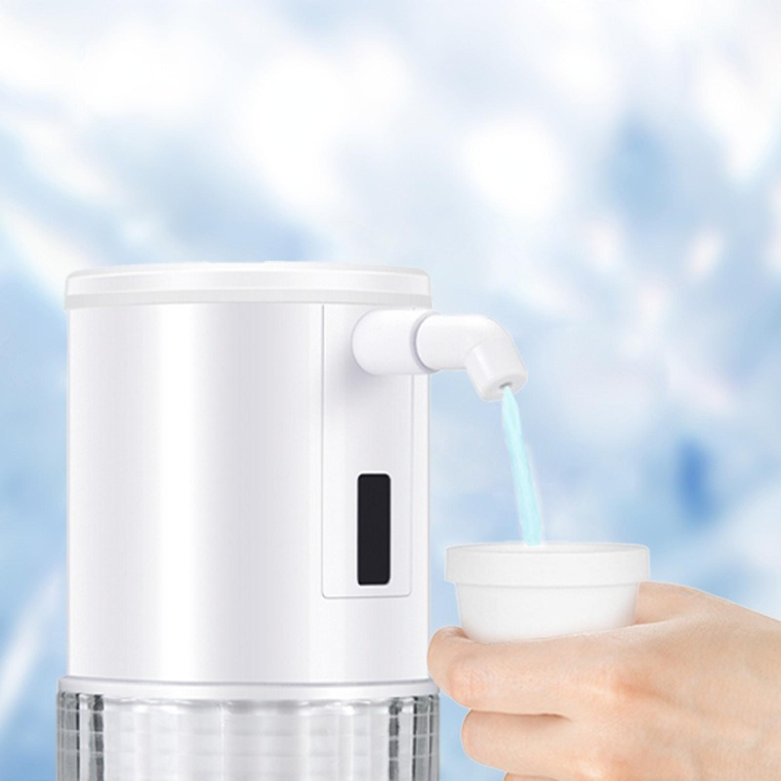 Ein weißer Seifenspender gießt blaue Flüssigkeit in einen kleinen weißen Becher, der von einer Hand gehalten wird.