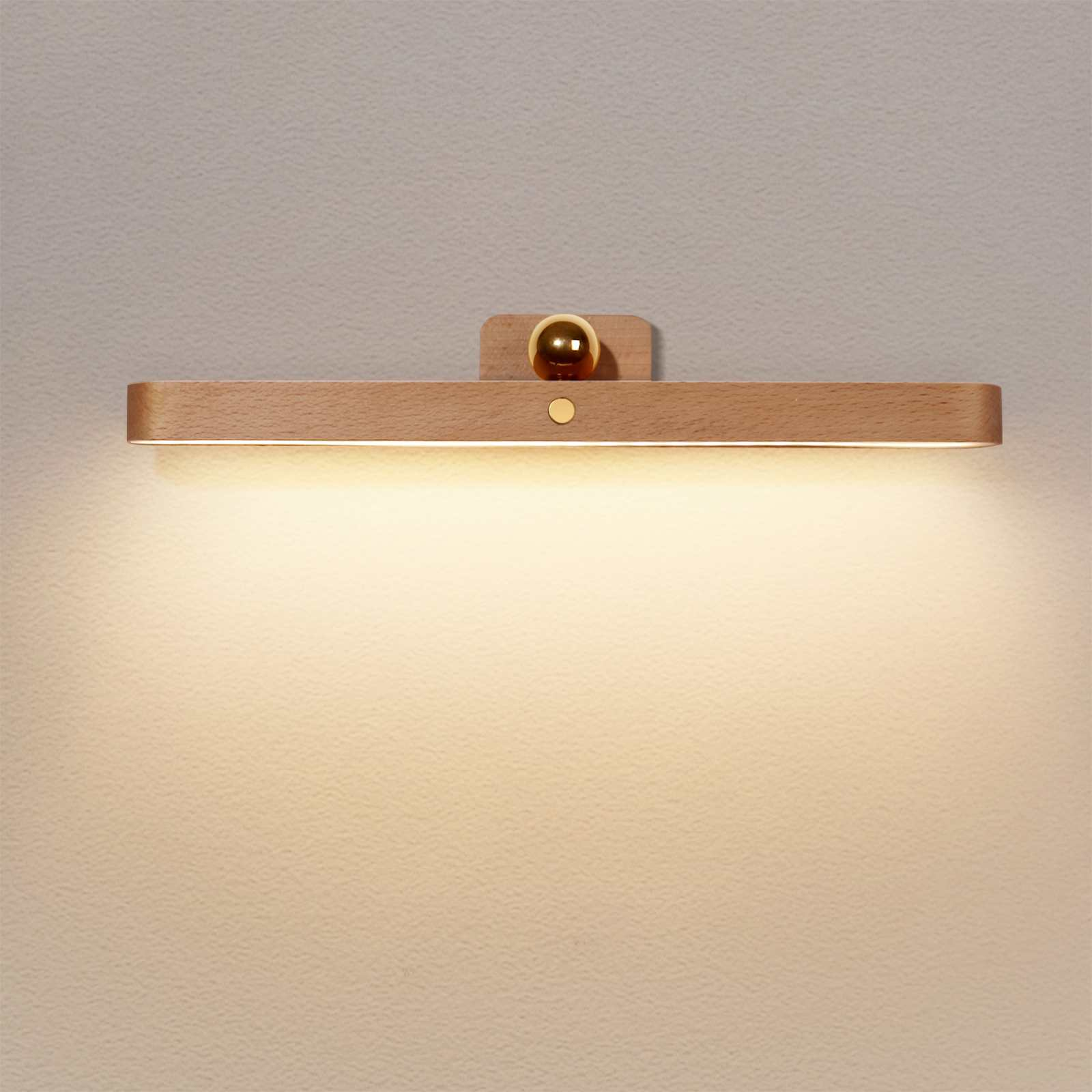 Eine hölzerne Wandleuchte mit einem goldenen, kugelförmigen Detail und einem kleinen Knopf. Das Licht scheint auf die Wand.