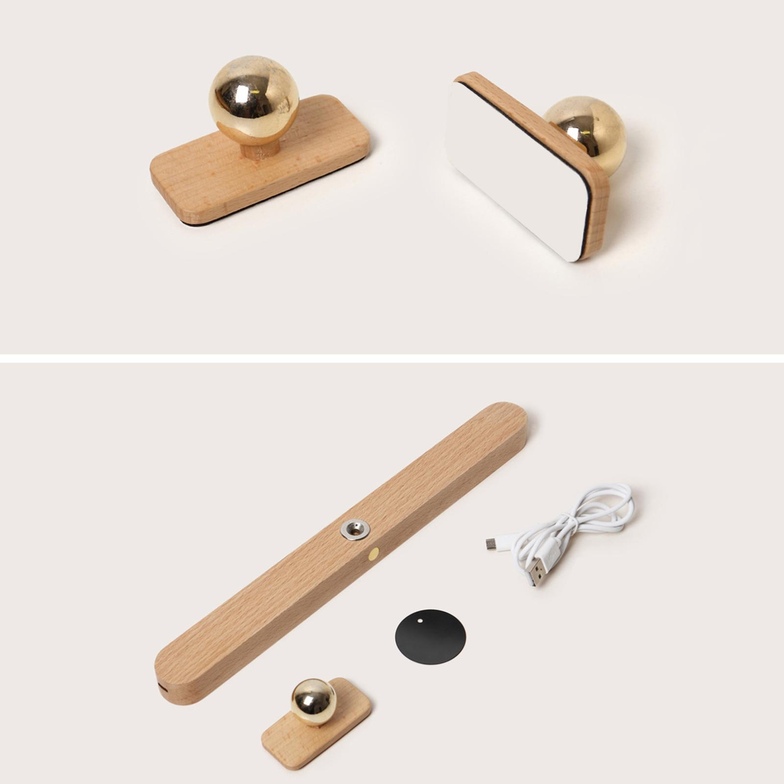 Holzstempel mit goldenen Kugelaufsätzen. Einer hat eine weiße Oberfläche. Außerdem ein langes Holzteil, eine Scheibe und ein USB-Kabel.