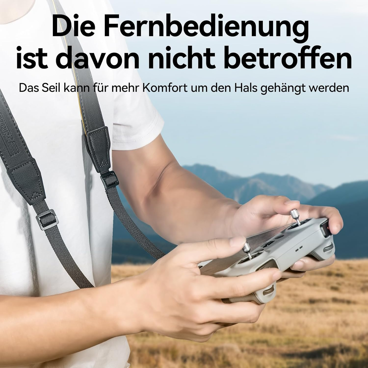 Eine Person hält eine graue Fernbedienung. Ein Gurt ist an der Fernbedienung und um den Hals befestigt. Der Hintergrund ist verschwommen.