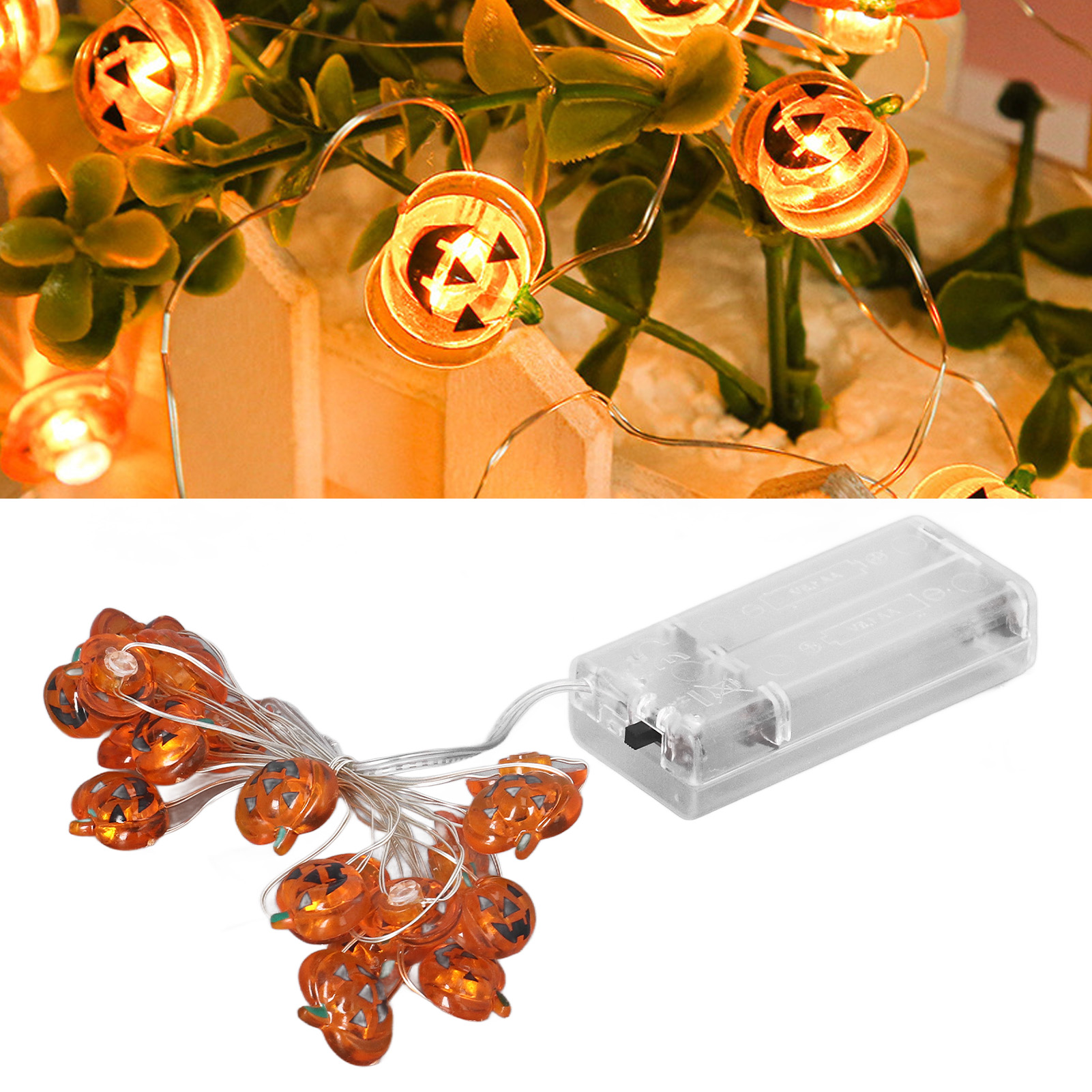 Orangefarbene Kürbislichter an einem Draht, mit grünen Blättern. Ein Akku-Pack befindet sich rechts.