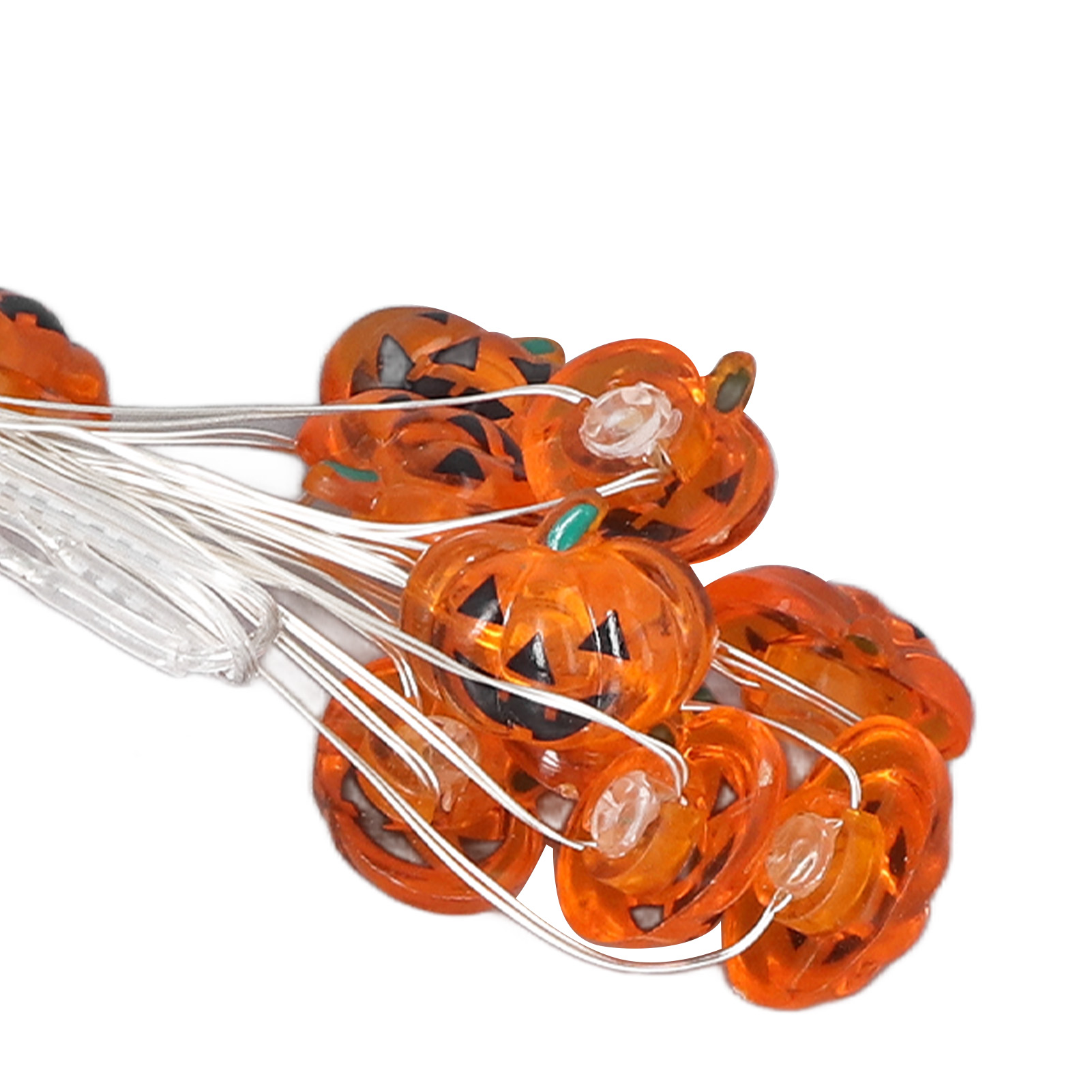 Schnur aus orangefarbenen Kürbislichtern mit schwarzen Gesichtern auf weißen Drähten, vor weißem Hintergrund, für Halloween.