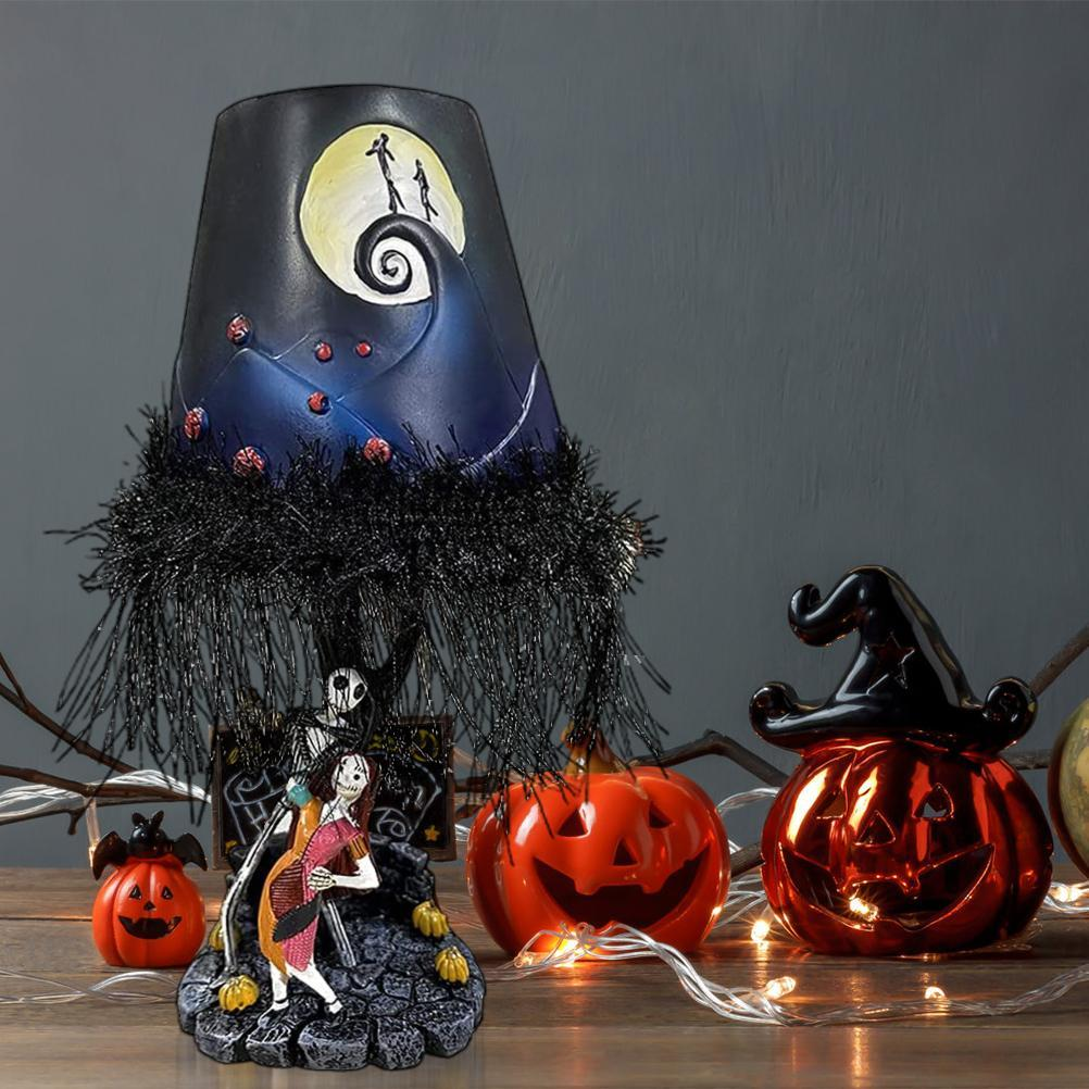 Halloween-Lampe mit Jack- und Sally-Figuren, Kürbissen und einem Hexenhut. Die Lampe zeigt eine Mondschein-Szene.