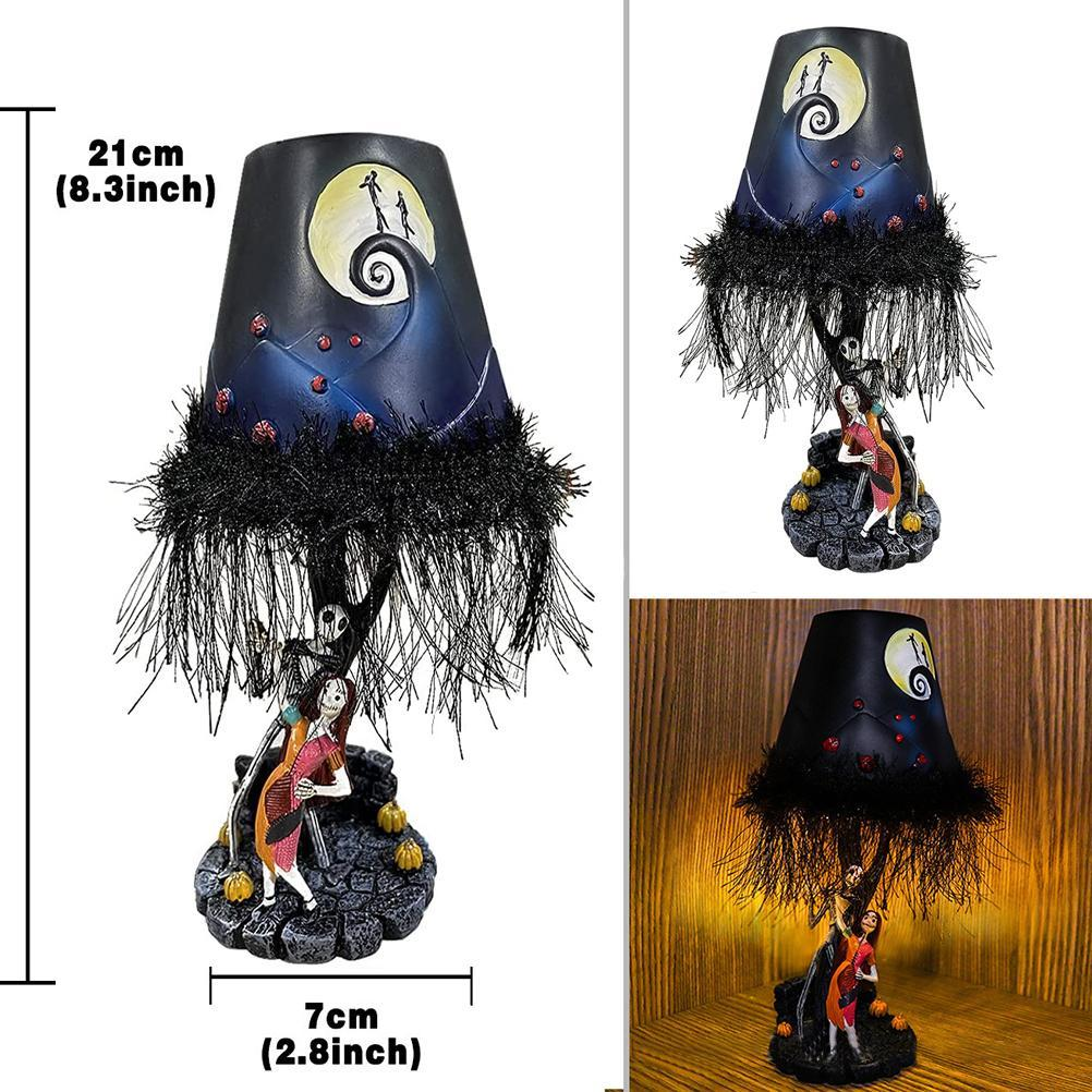 Eine Halloween-Lampe mit dunklem Schirm, Mondszene und einer Figur einer Frau auf einer Basis mit Kürbissen.