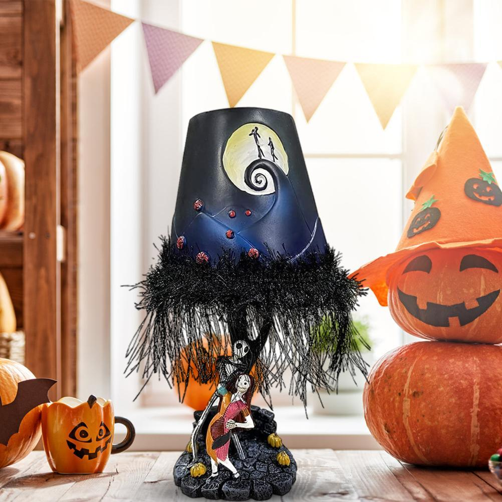 Halloween-Lampe mit dem Thema Nightmare Before Christmas. Kürbisse, ein Hexenhut und eine Fledermaus-Tasse sind in der Szene.