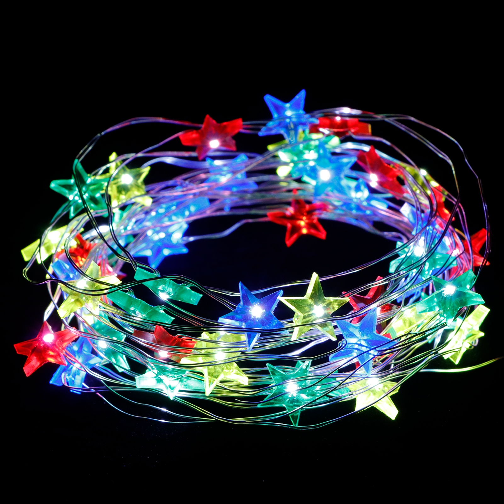 Schnur bunter sternförmiger Lichterketten auf schwarzem Hintergrund.